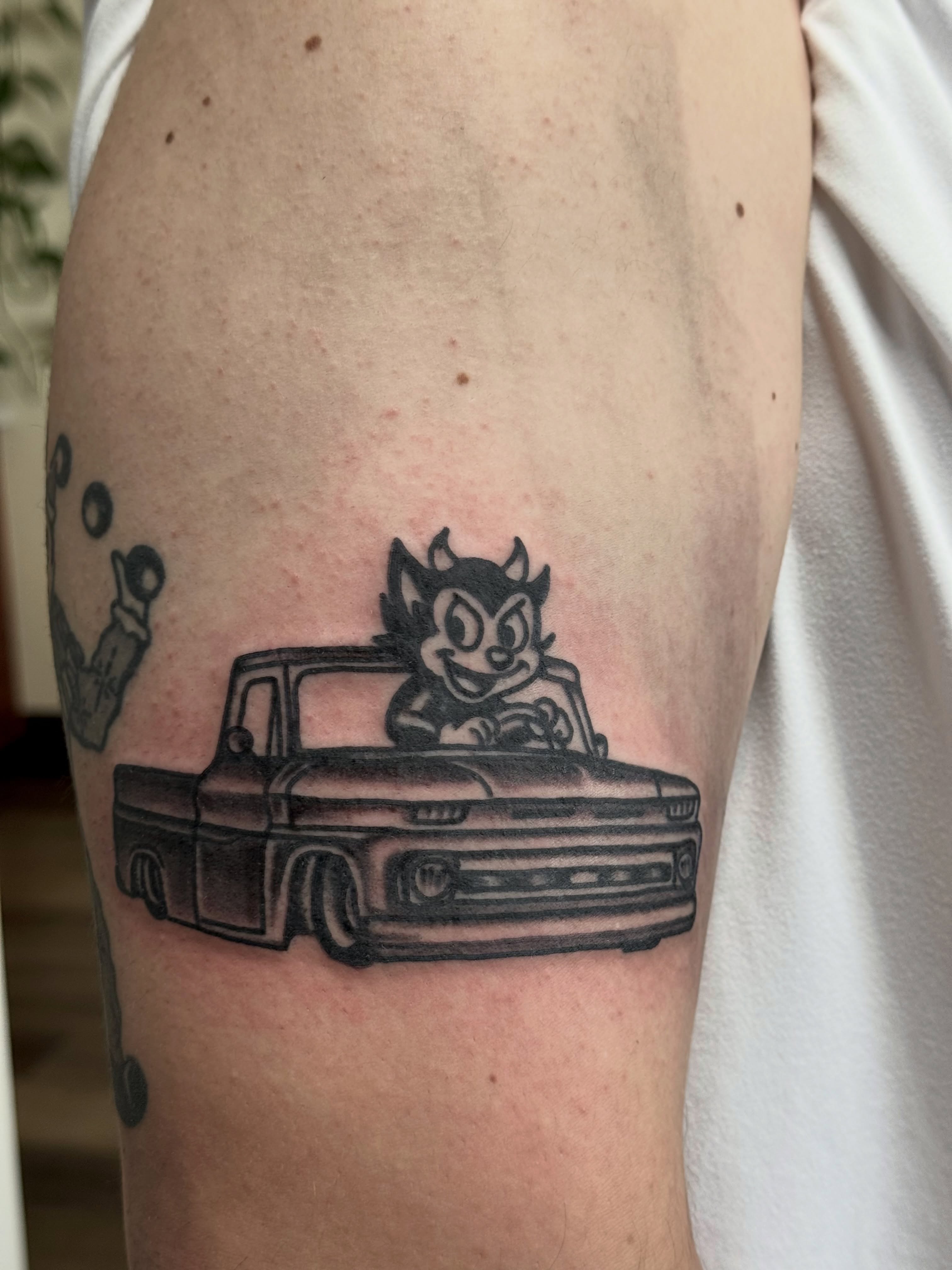 Truck with devil character black and grey tattoo on the forearm by San Diego Tattoo Artist - 𝔍𝔞𝔠𝔬𝔟 𝔓𝔞𝔫𝔦𝔞𝔤𝔲𝔞