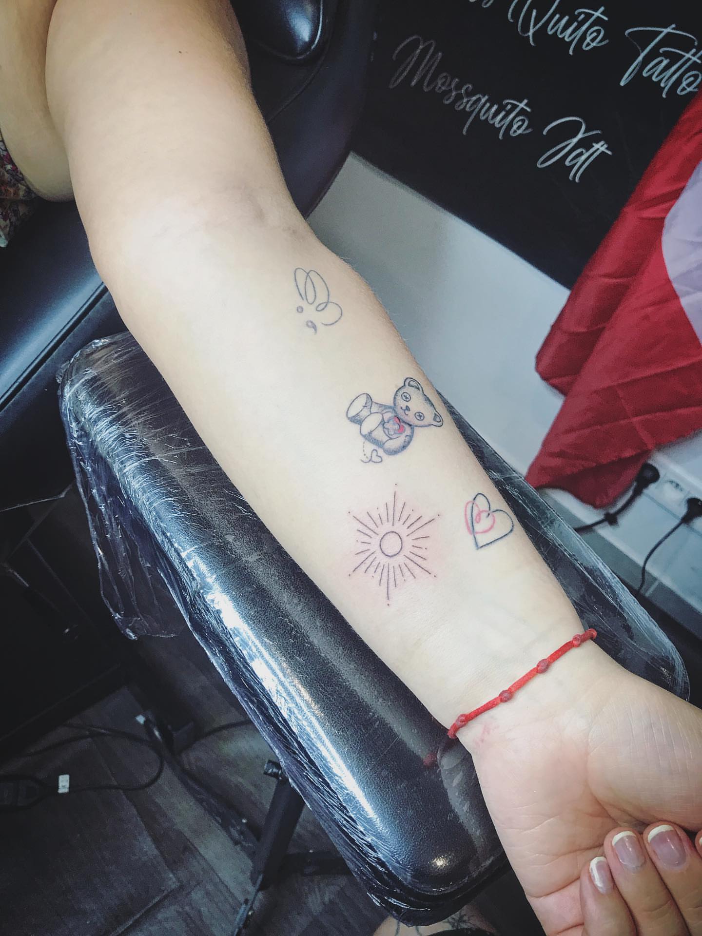Butterfly, teddy bear, sunburst, heart dotwork tattoo on the forearm by Moss Quito Tattoo