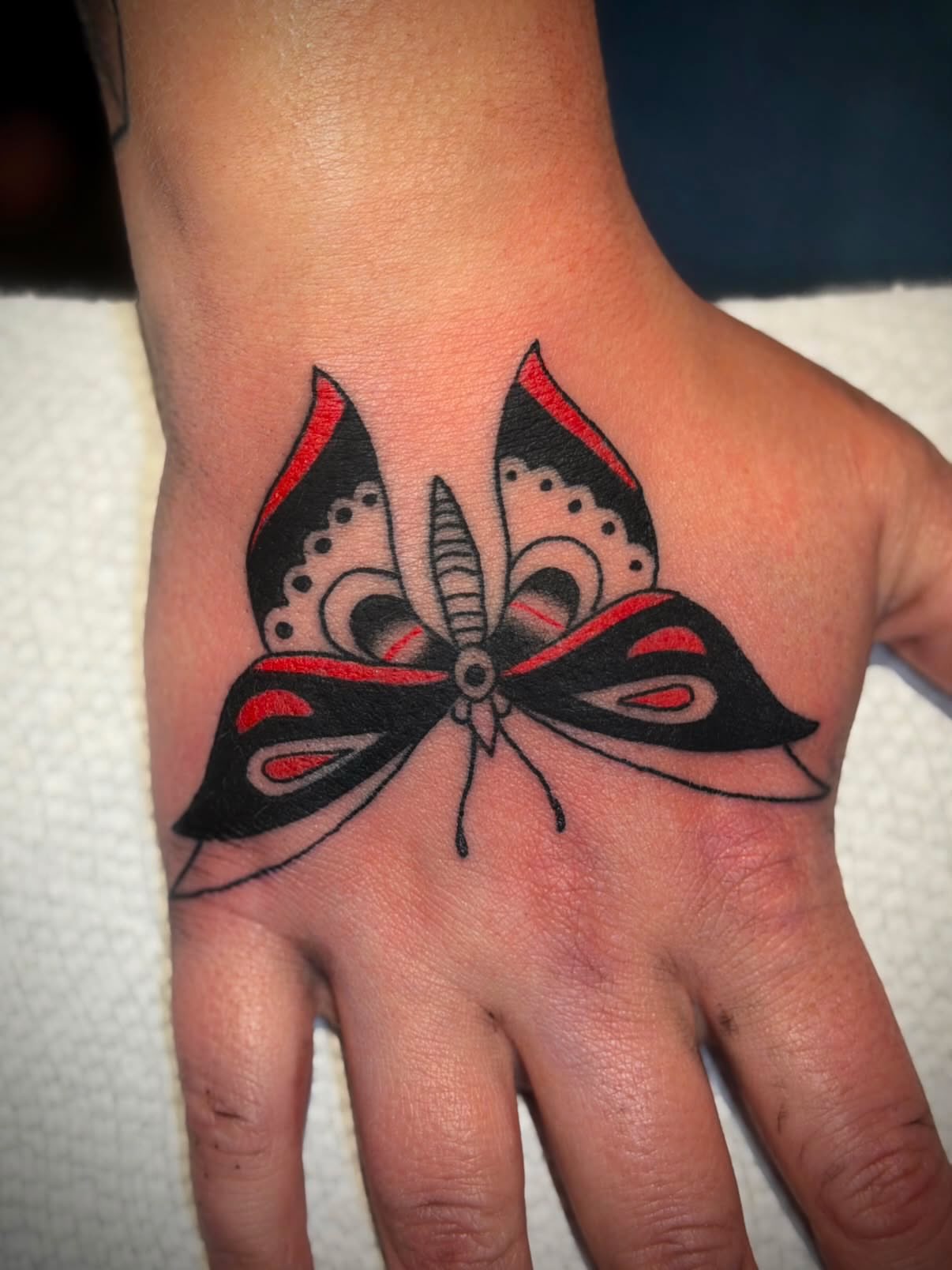 Butterfly American traditional tattoo on the hand by Diego Treviño