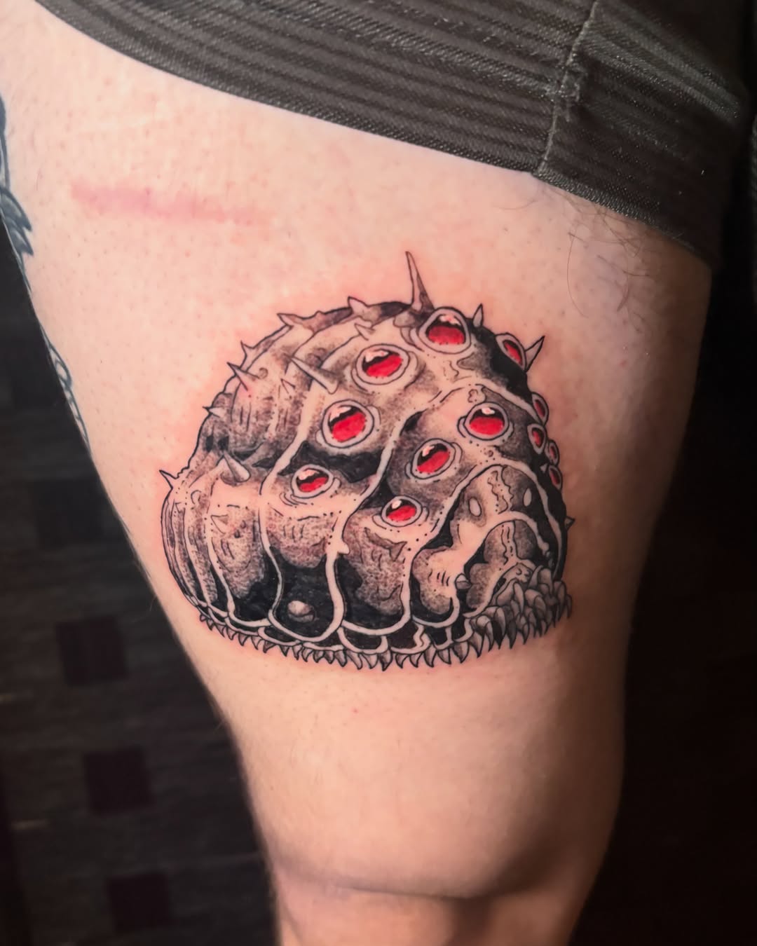 Spiky creature black and grey tattoo on the thigh by Abby Ruok, Midvale, Utah