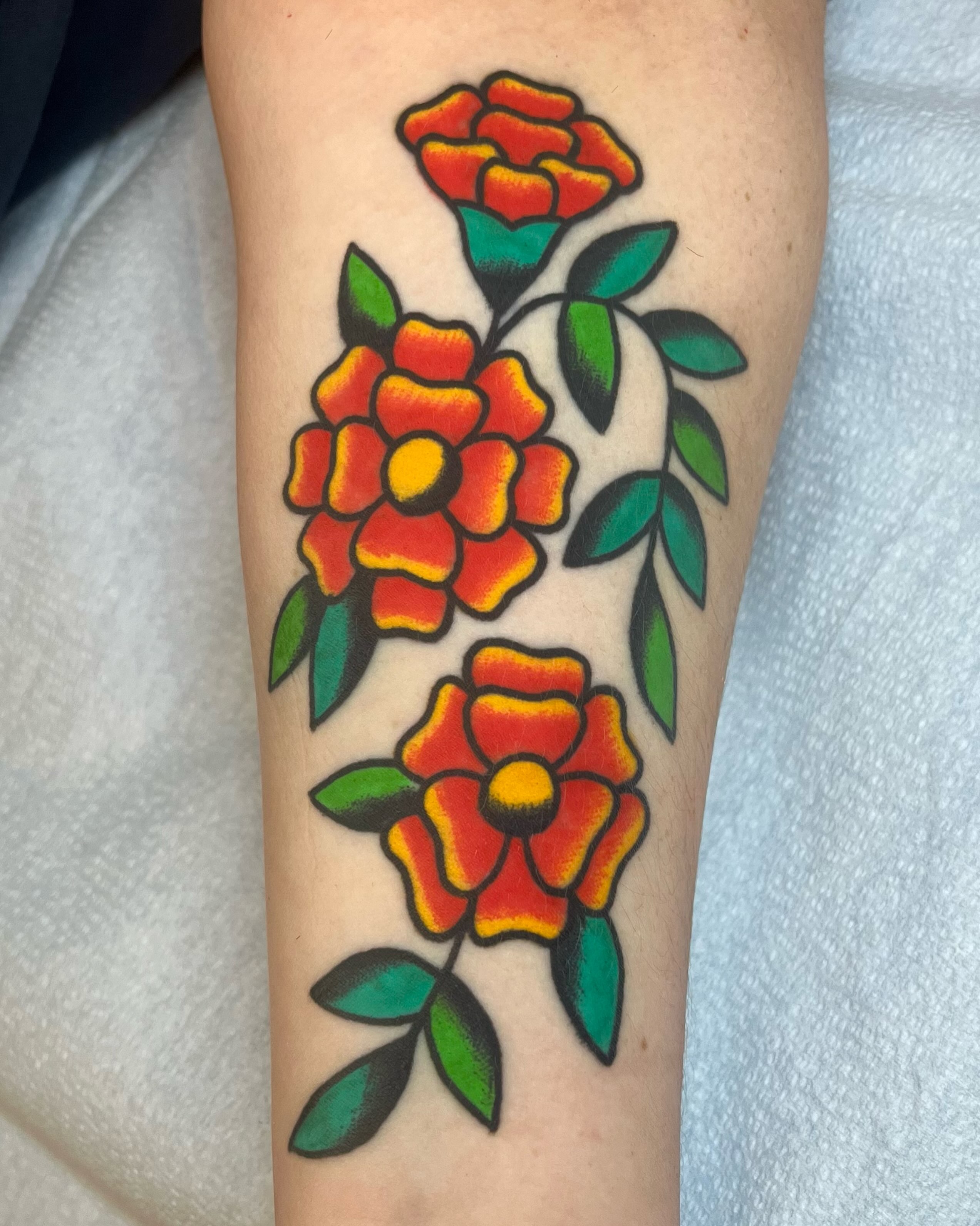 Flowers American traditional tattoo on the forearm by Em Adkins