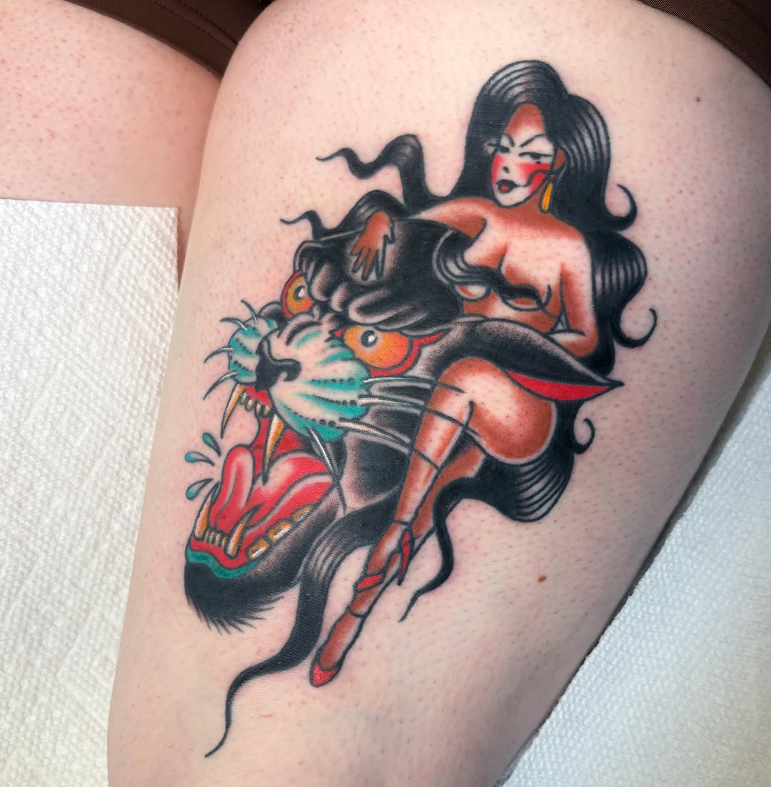 Woman riding cat American traditional tattoo on the thigh by Caeli Martin