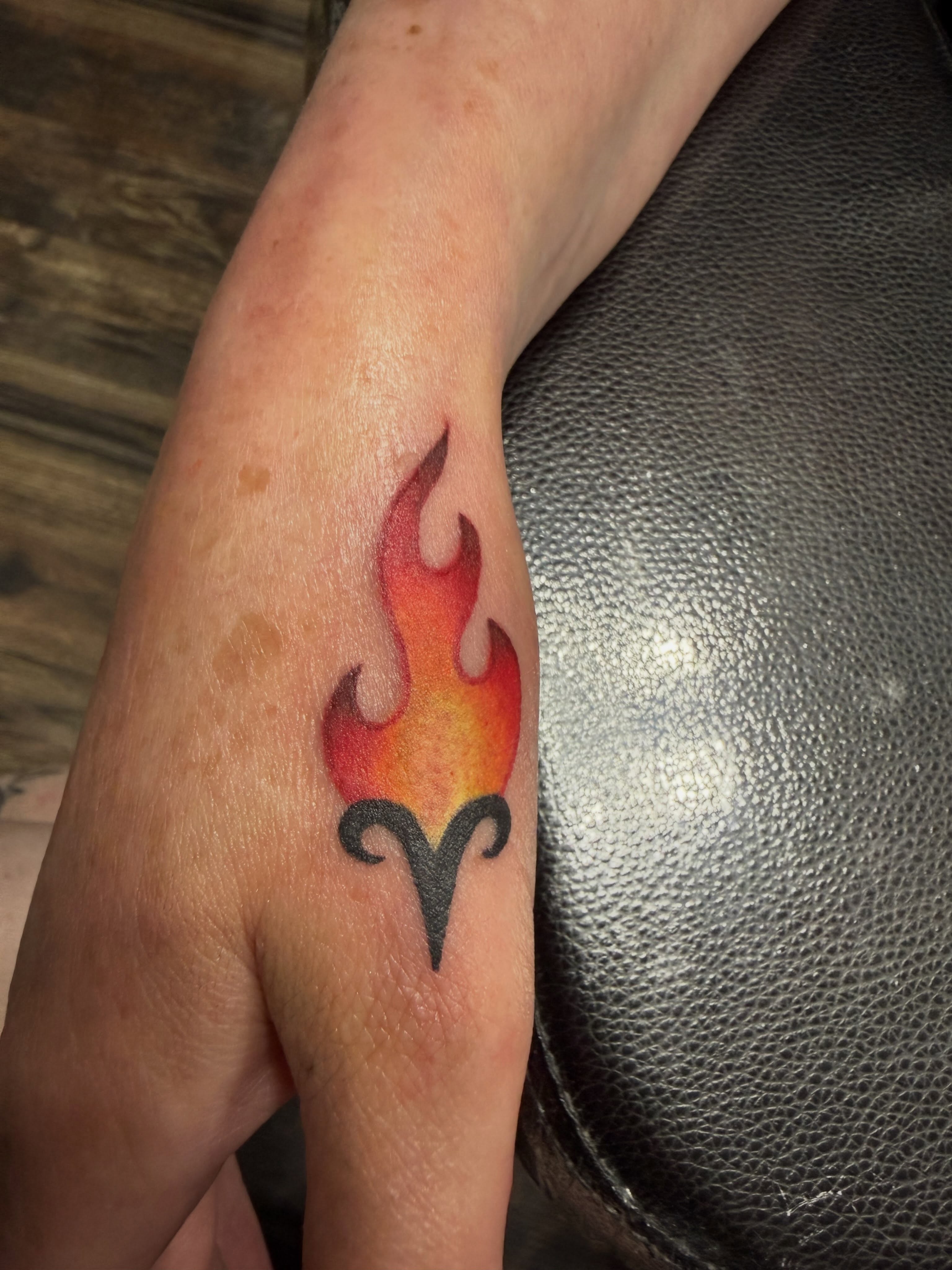 Flame with horns neo-traditional tattoo on the forearm by Abby Hofman