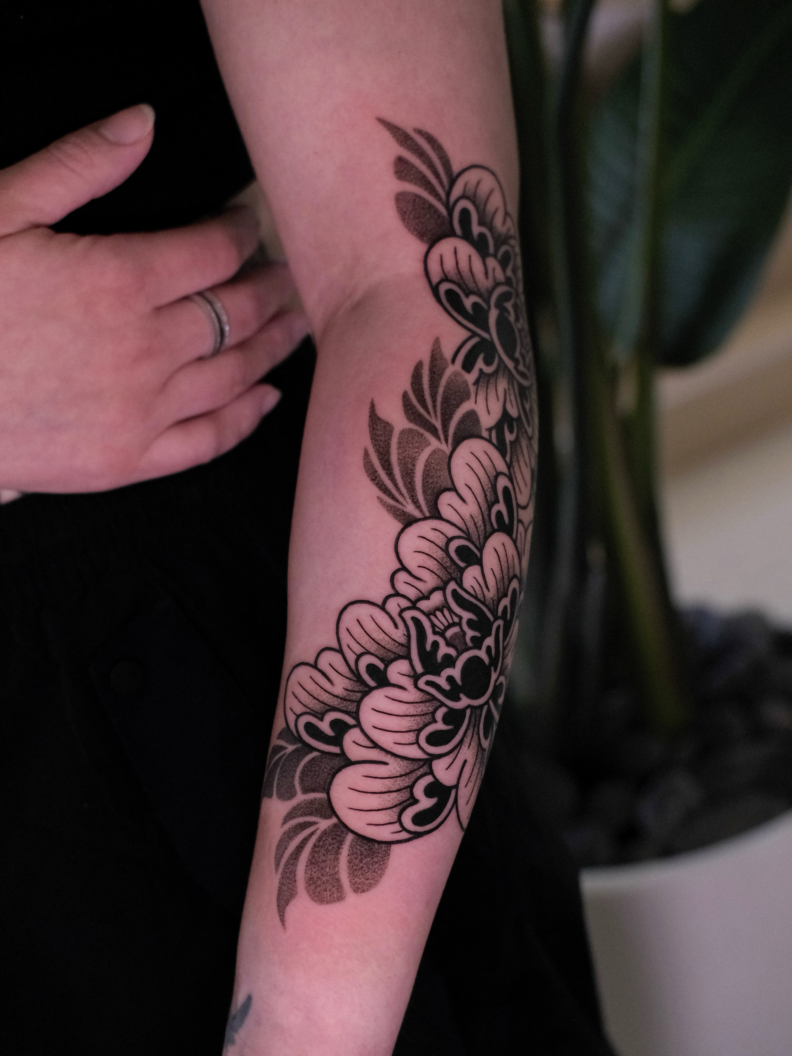 Floral design black and grey tattoo on the forearm by seattle tattoo artist