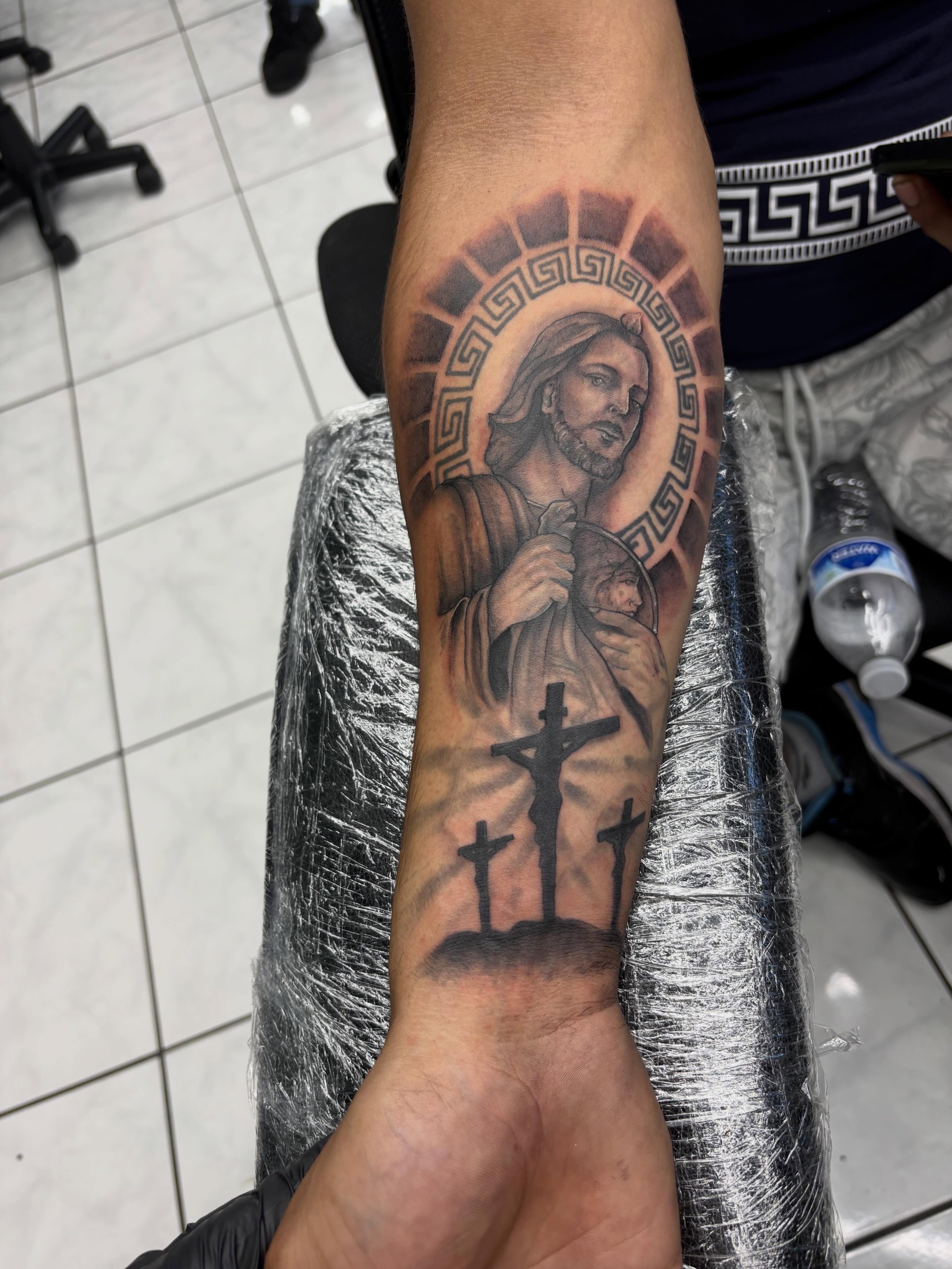 Religious figure with three crosses realism tattoo on the forearm by Shadows Tattoos