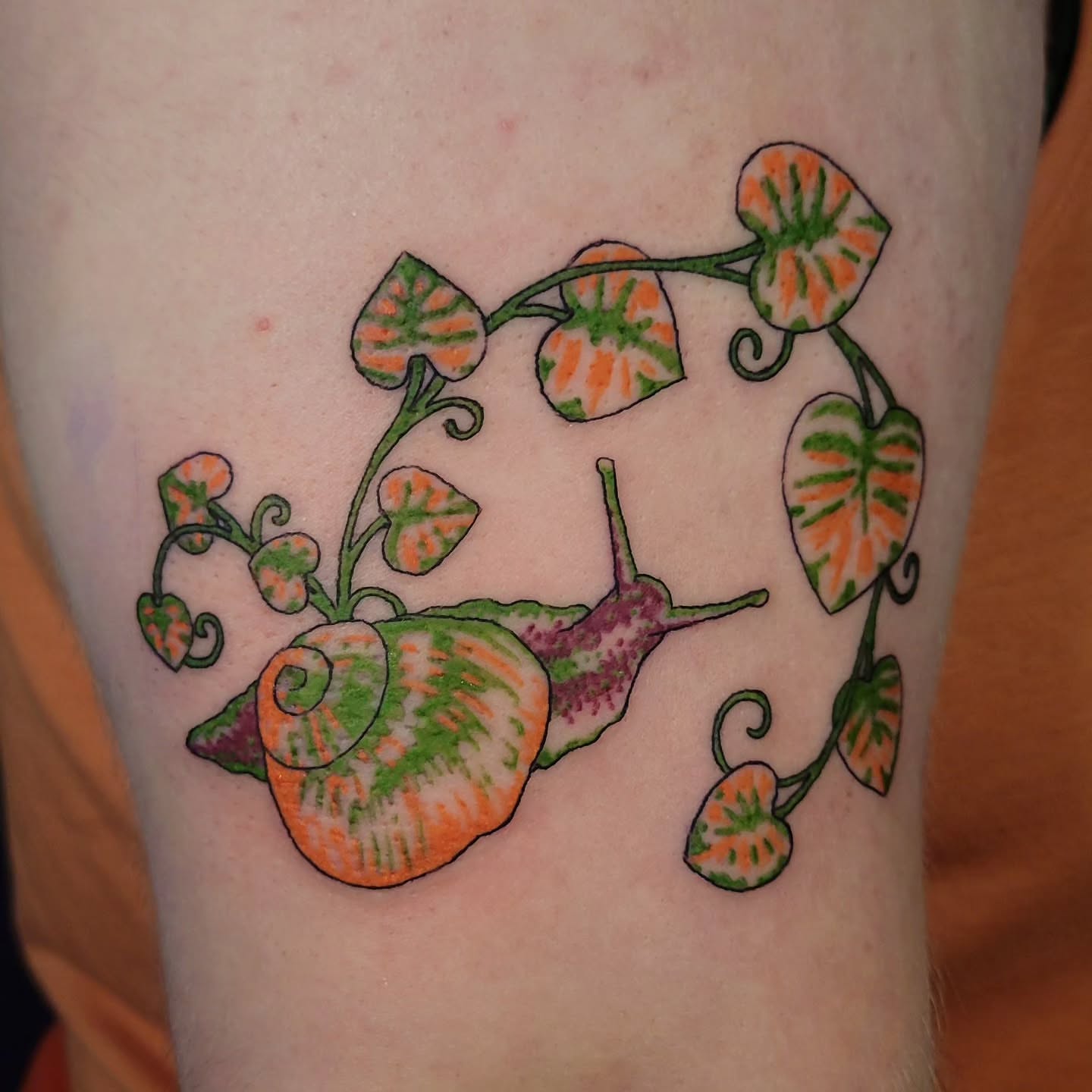 Snail and leaves new school tattoo on the thigh by Sarah Alba