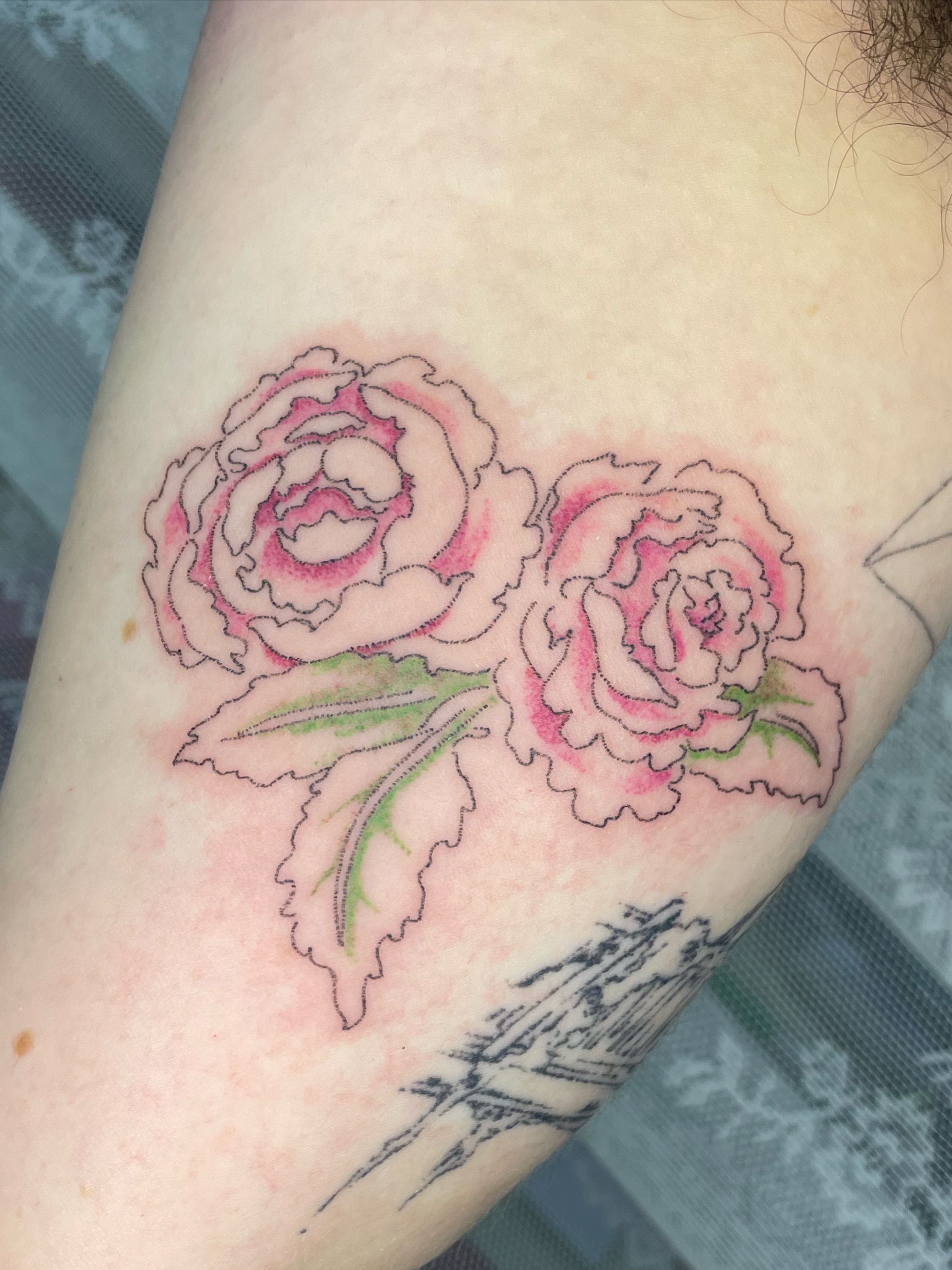 Peonies new school tattoo on the upper arm by cait