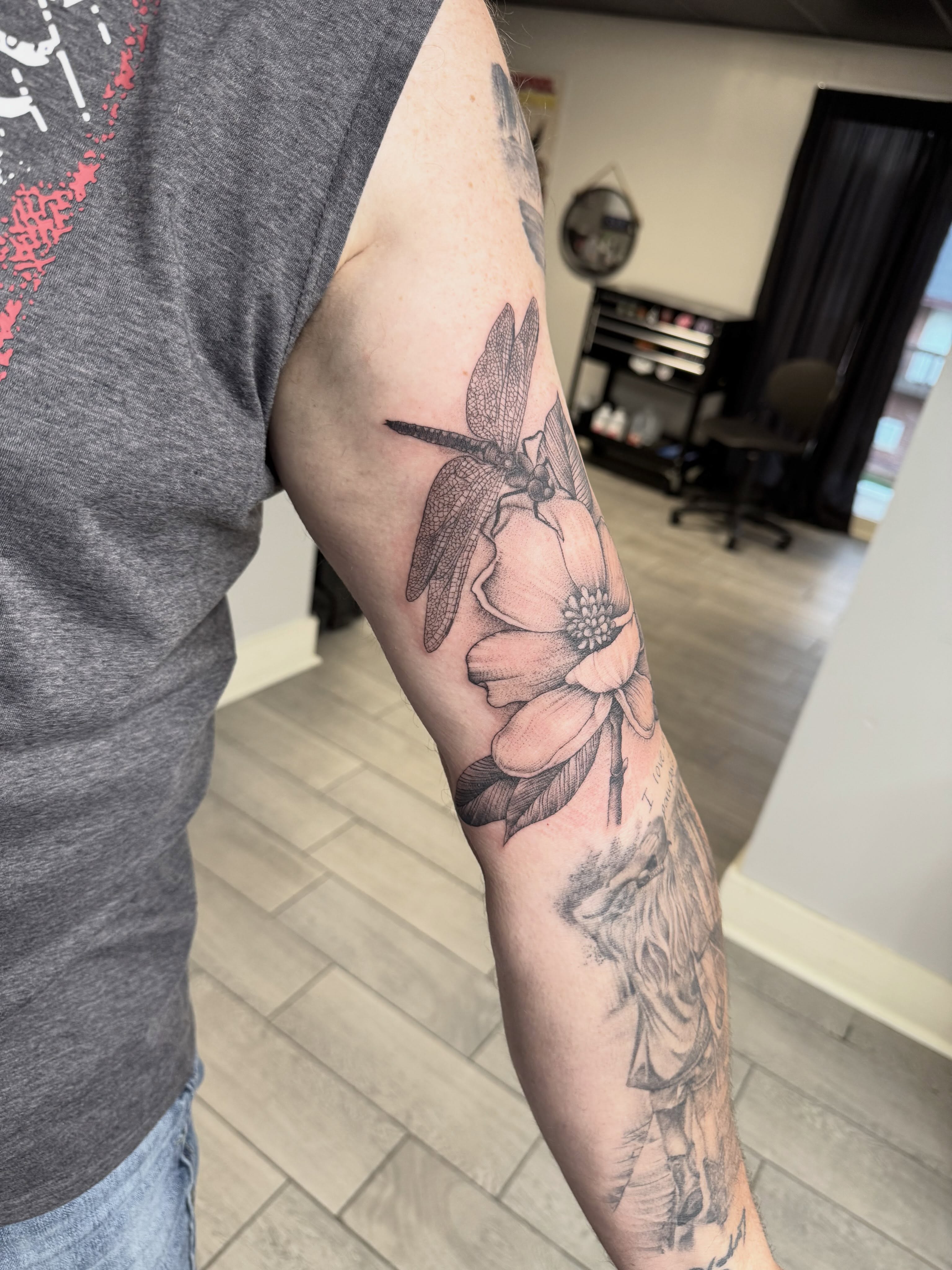 Dragonfly and flower realism tattoo on the forearm by Joey Flaherty