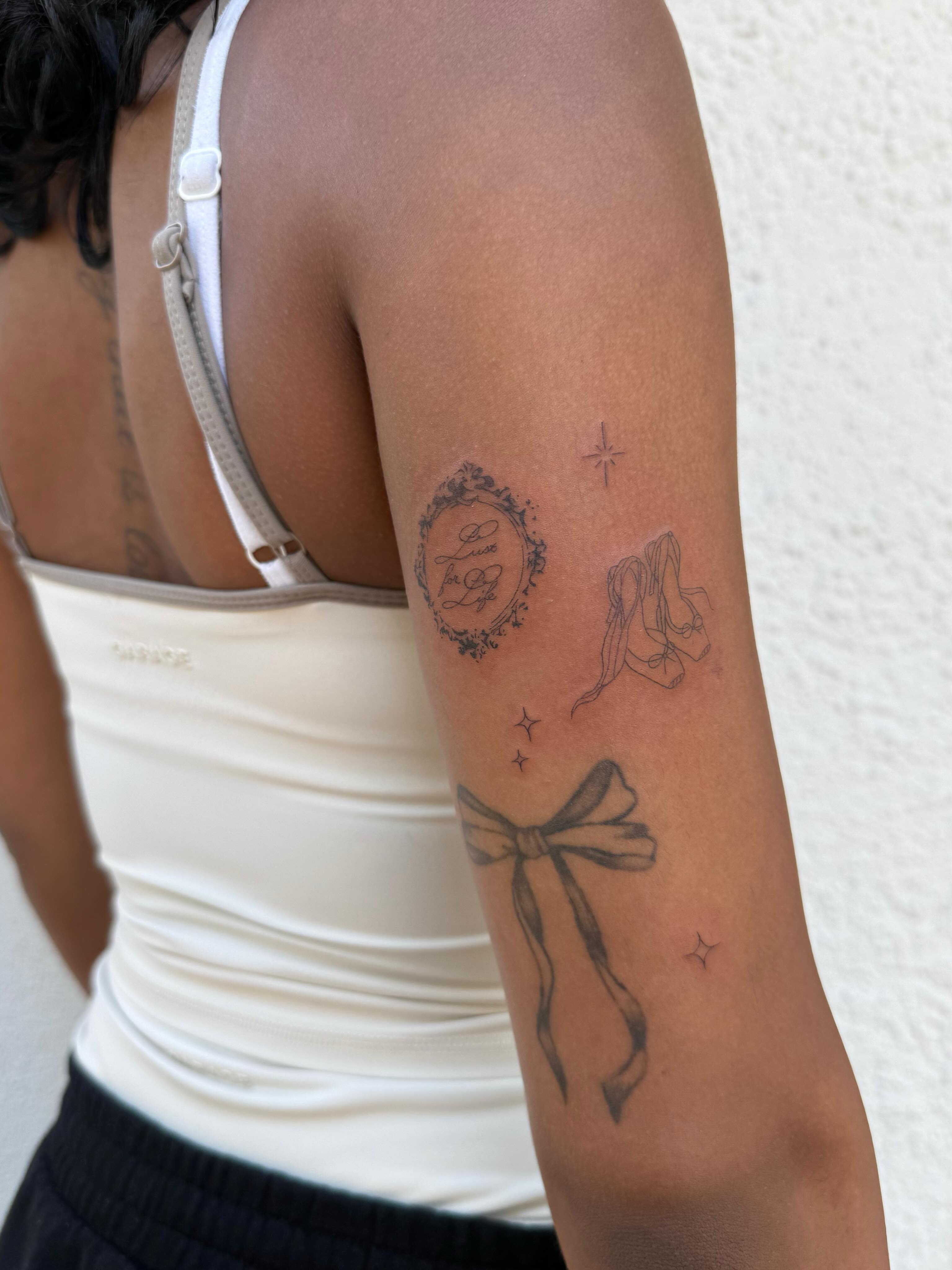 Bow and ribbon black and grey tattoo on the forearm by TATTOO & PIERCING ARTIST ₊˚⊹ ᰔ