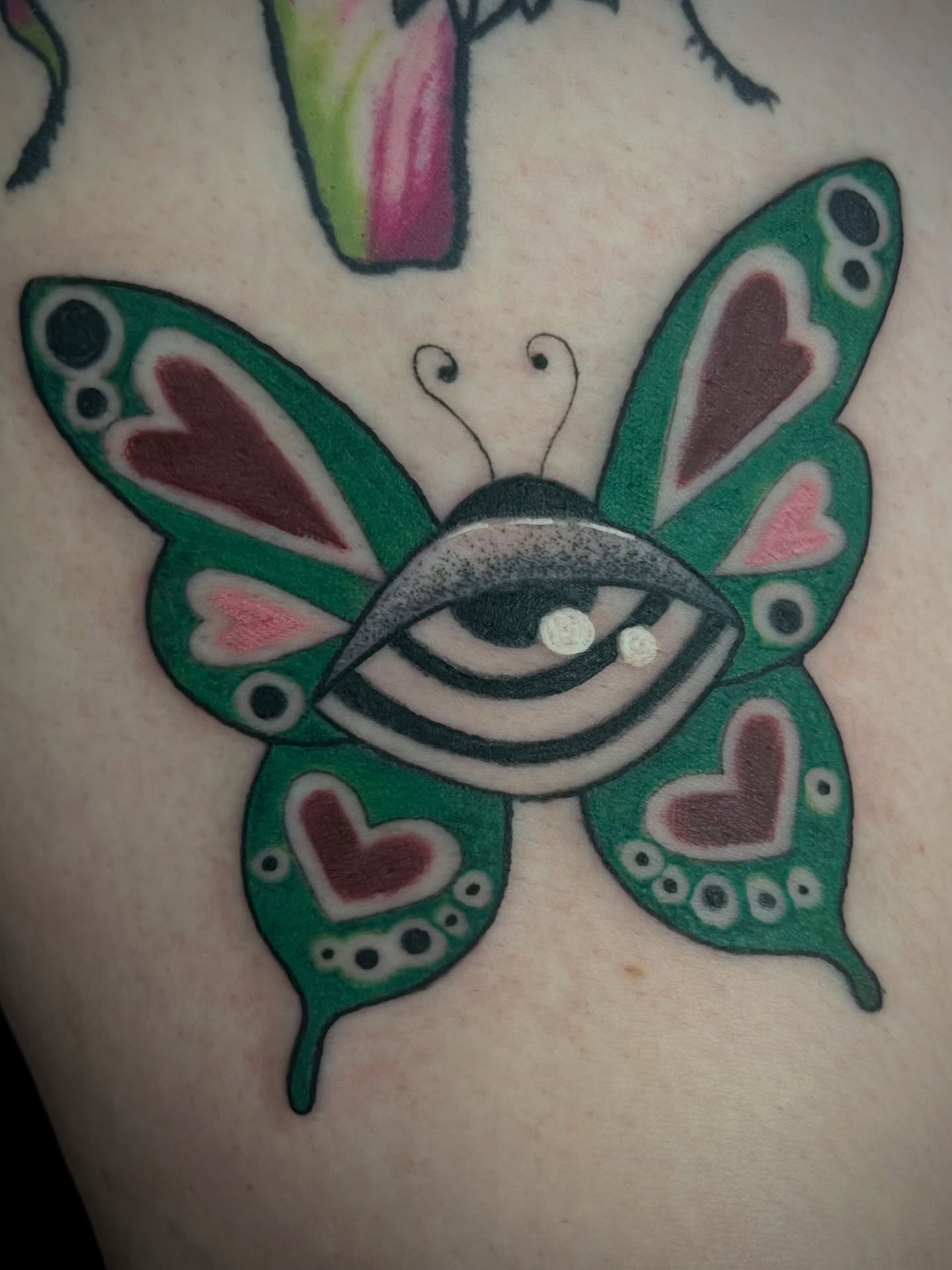 Eye butterfly American traditional tattoo on the upper arm by Freya Petersen
