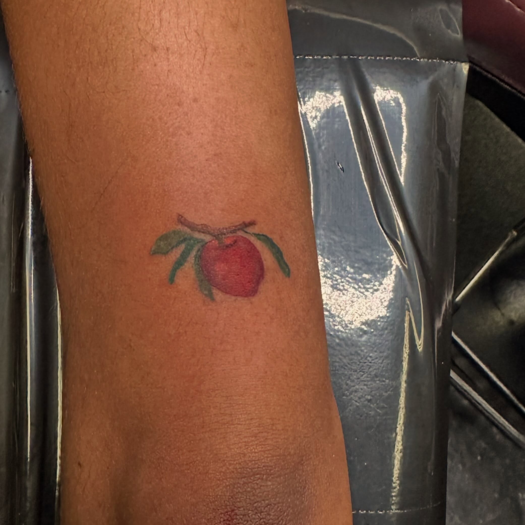 Apple American traditional tattoo on the forearm by Red (Owner), Brooklyn, New York