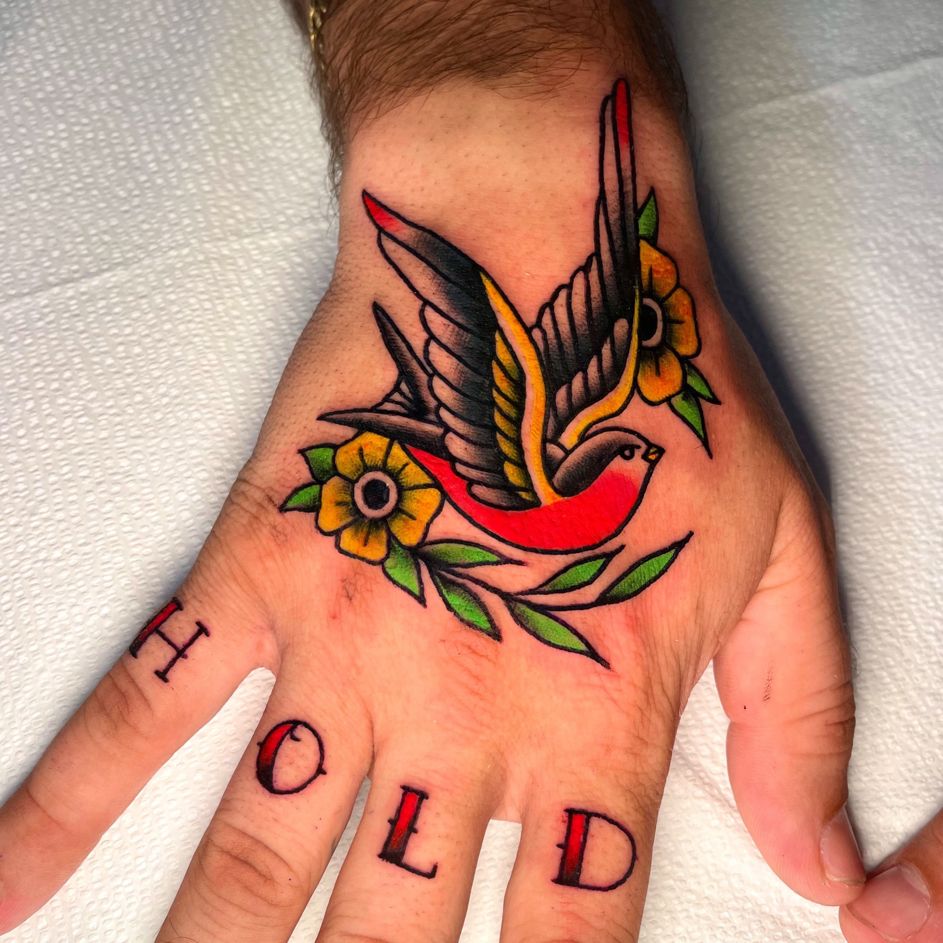 Bird and flowers American traditional tattoo on the hand by Brooke Kresco