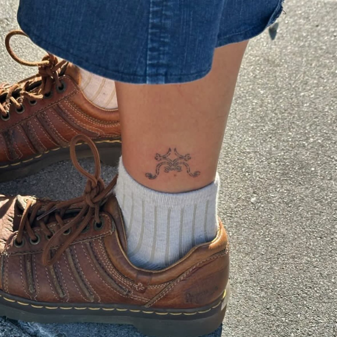 Skull and crossbones black and grey tattoo on the leg by kari