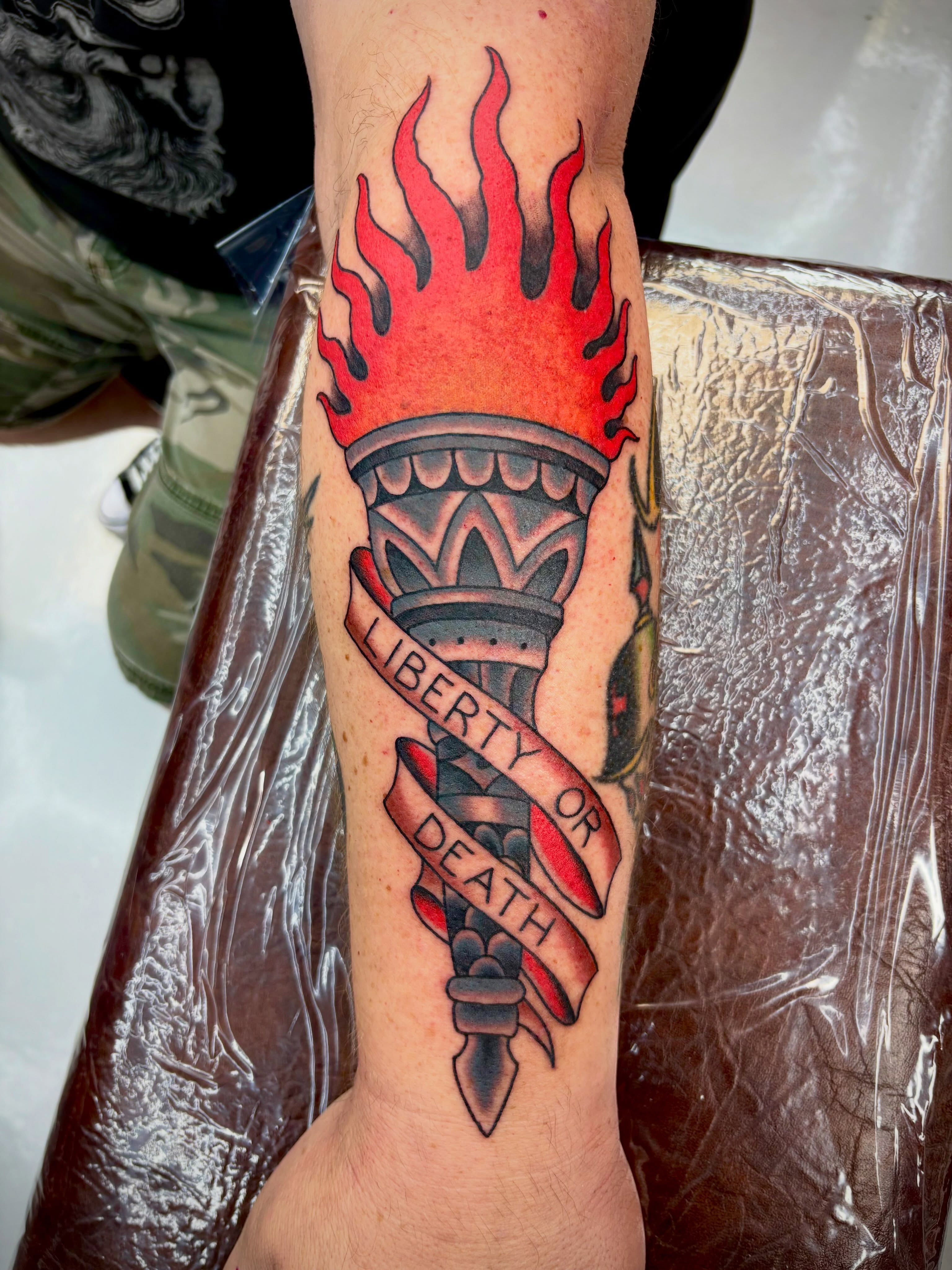 Torch with flame American traditional tattoo on the forearm by Dustin Hysell