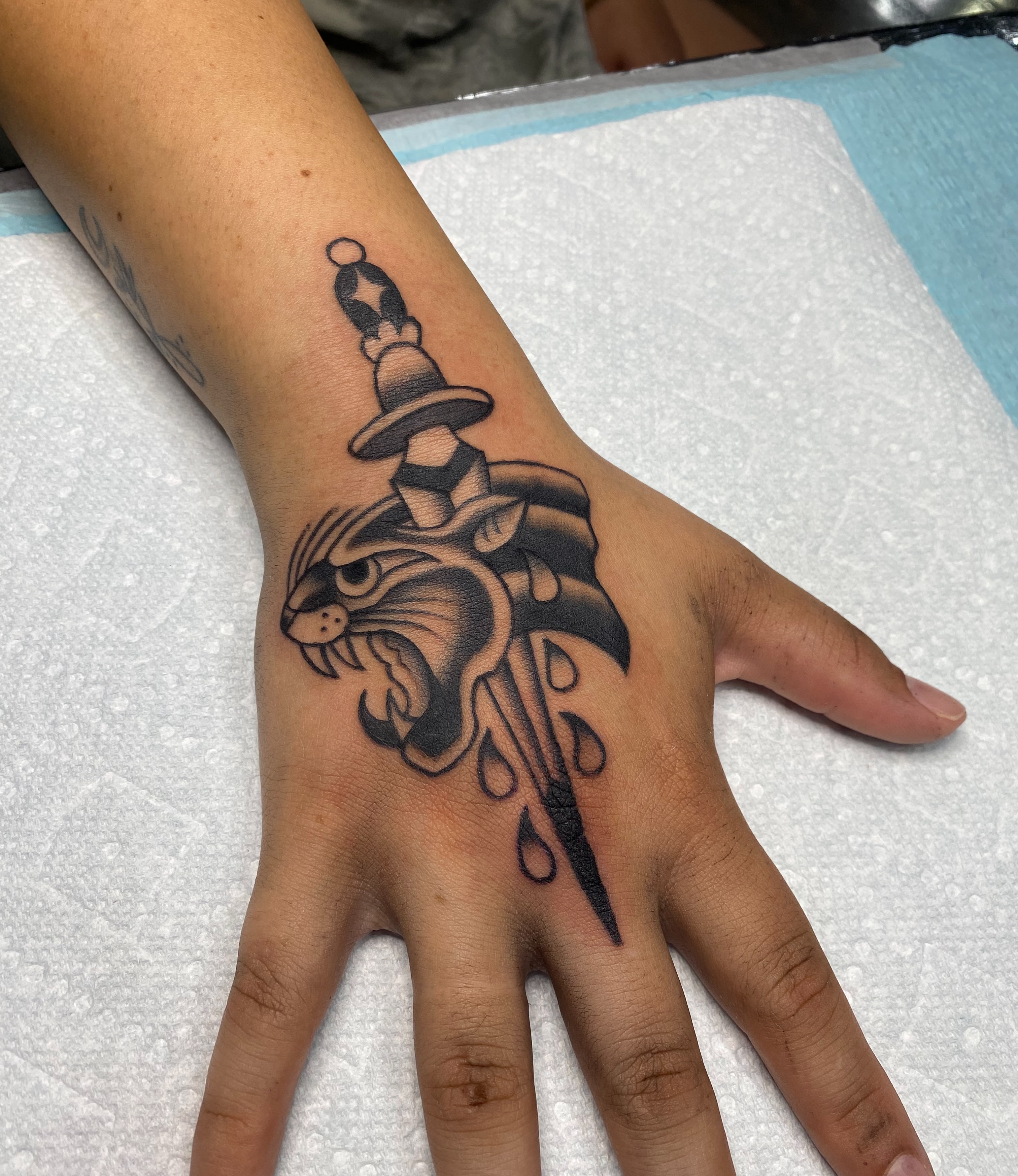 Cat and dagger black and grey tattoo on the hand by Karl Hegwein, Portland, Oregon
