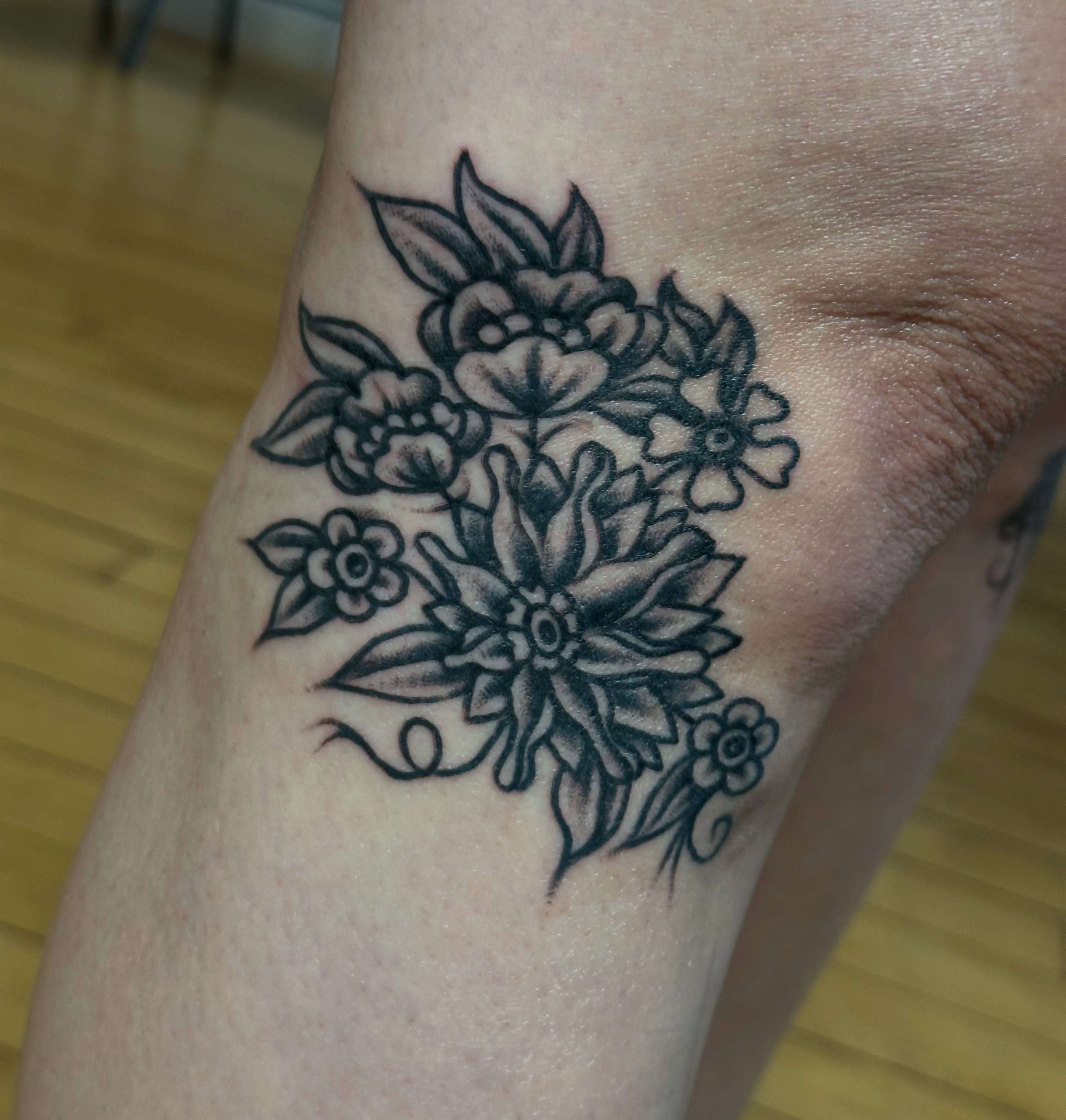 Floral bouquet black and grey tattoo on the forearm by Providence Tattooer