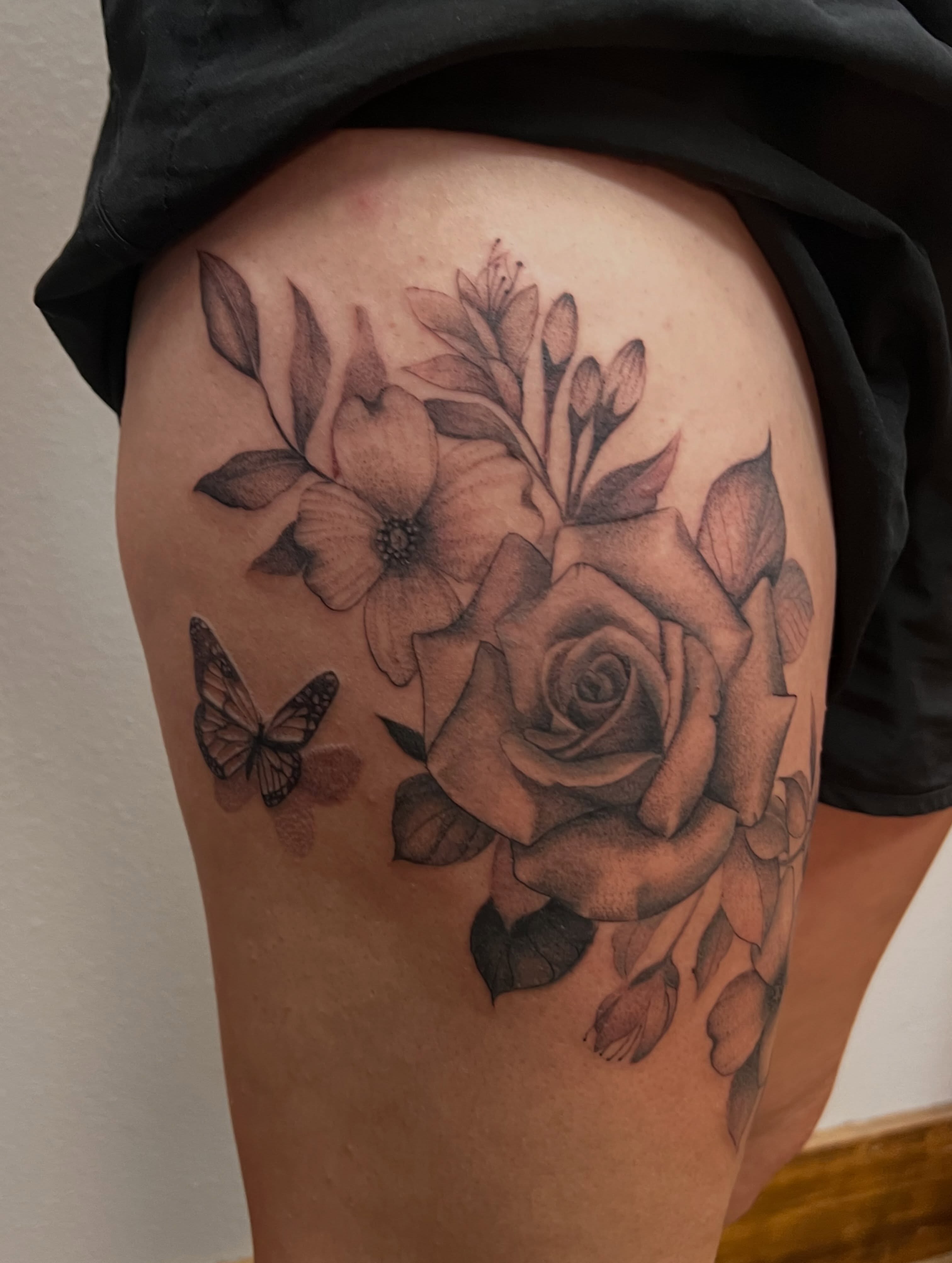 Rose and butterfly realism tattoo on the thigh by Rebecca Kern Tattoos