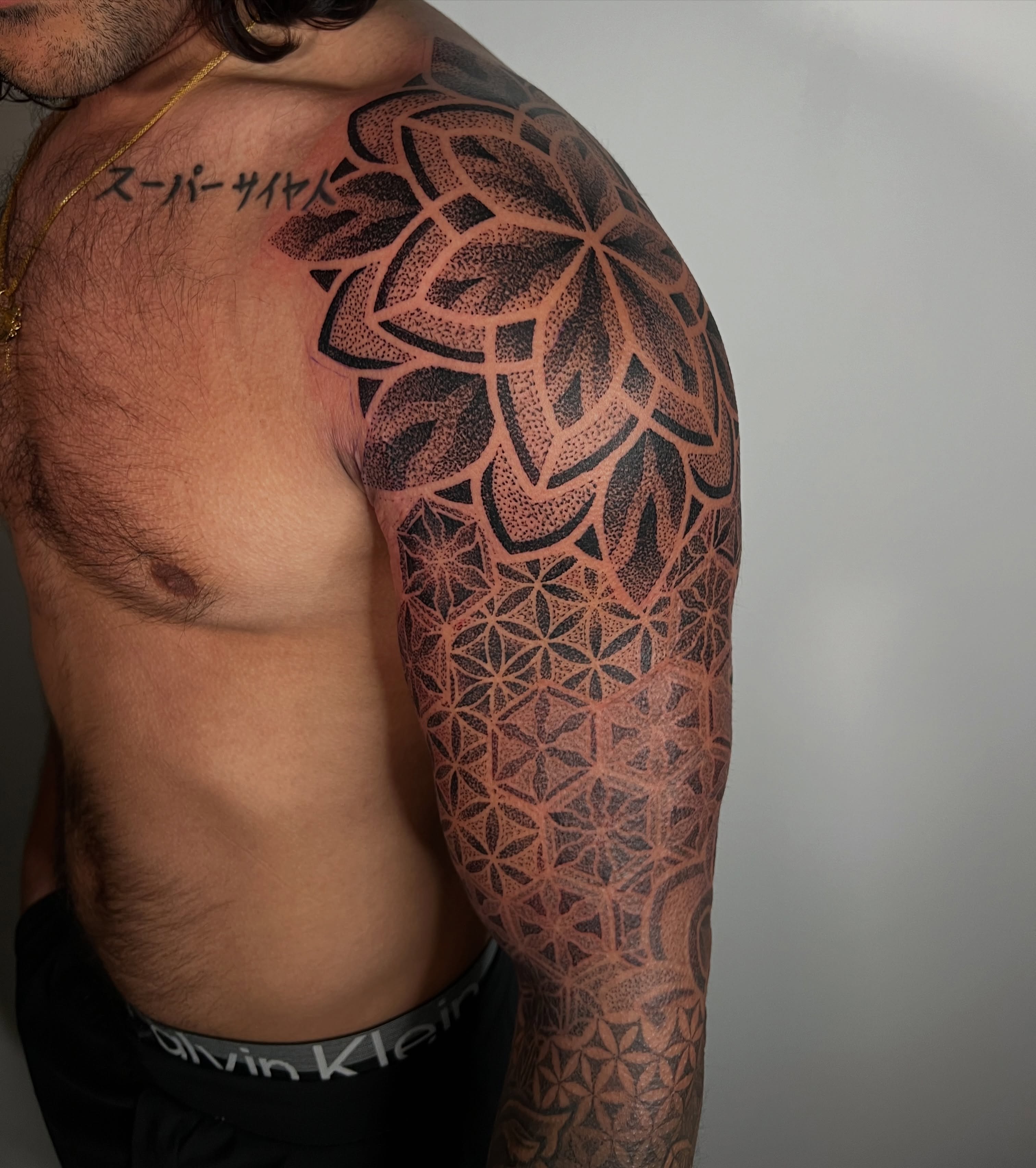 Geometric mandala dotwork tattoo on the upper arm by Riley