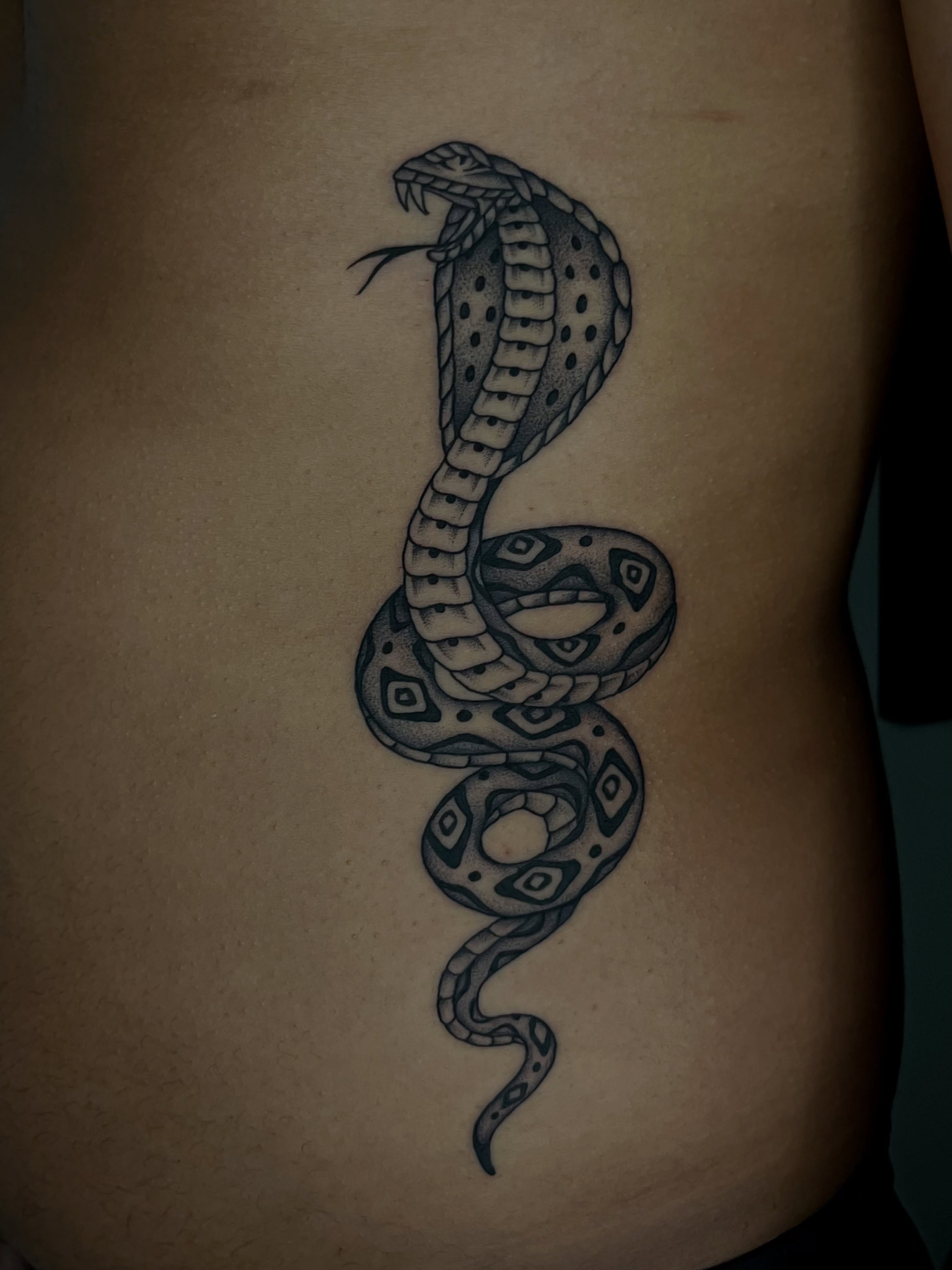 Snake black and grey tattoo on the ribs by Patrick Elijah