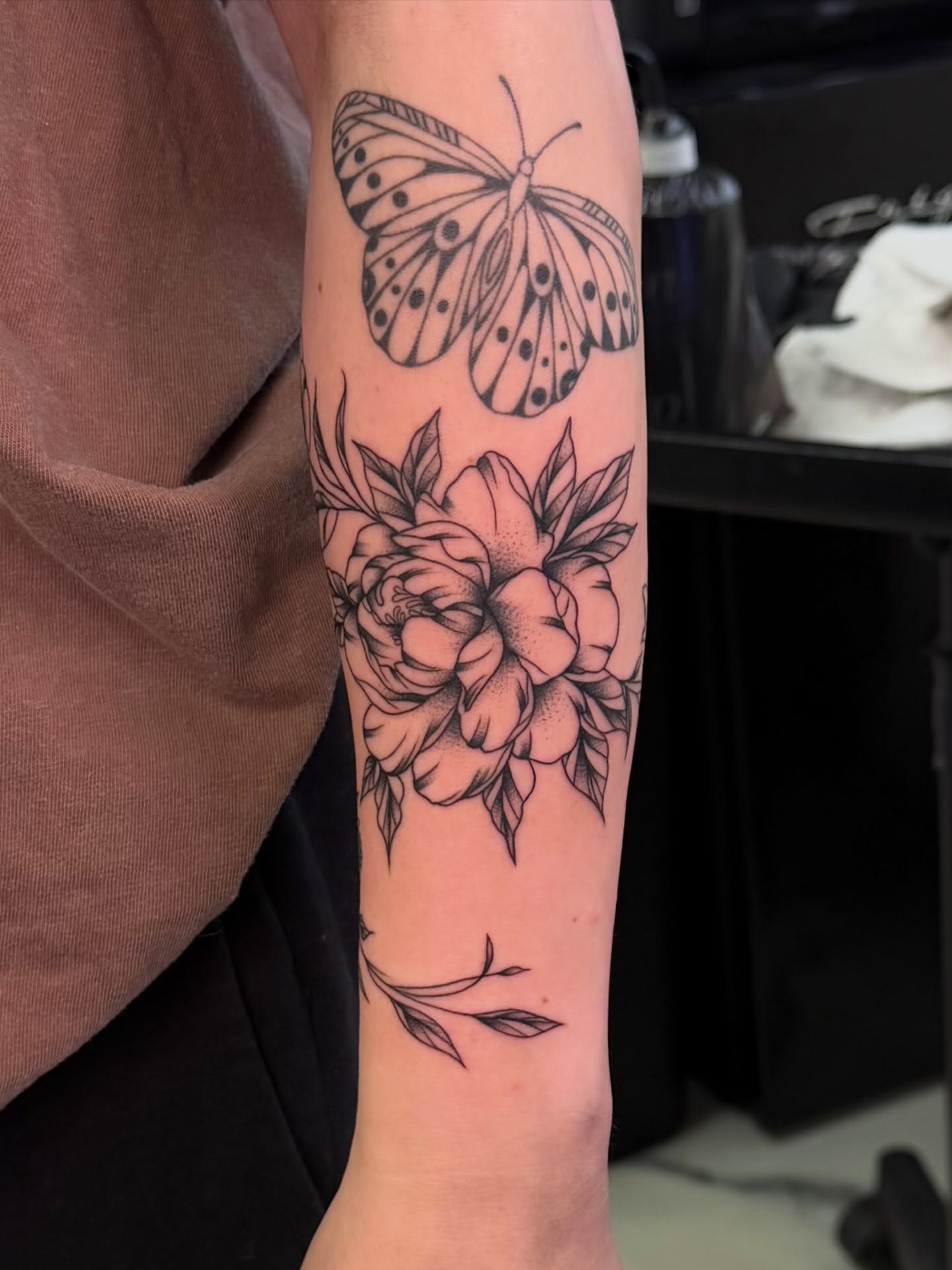 Butterfly and flowers black and grey tattoo on the forearm by haylie