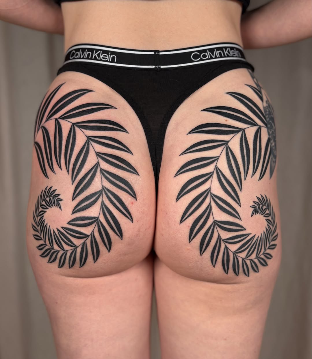 Palm leaves black and grey tattoo on the thigh by Anna Sage