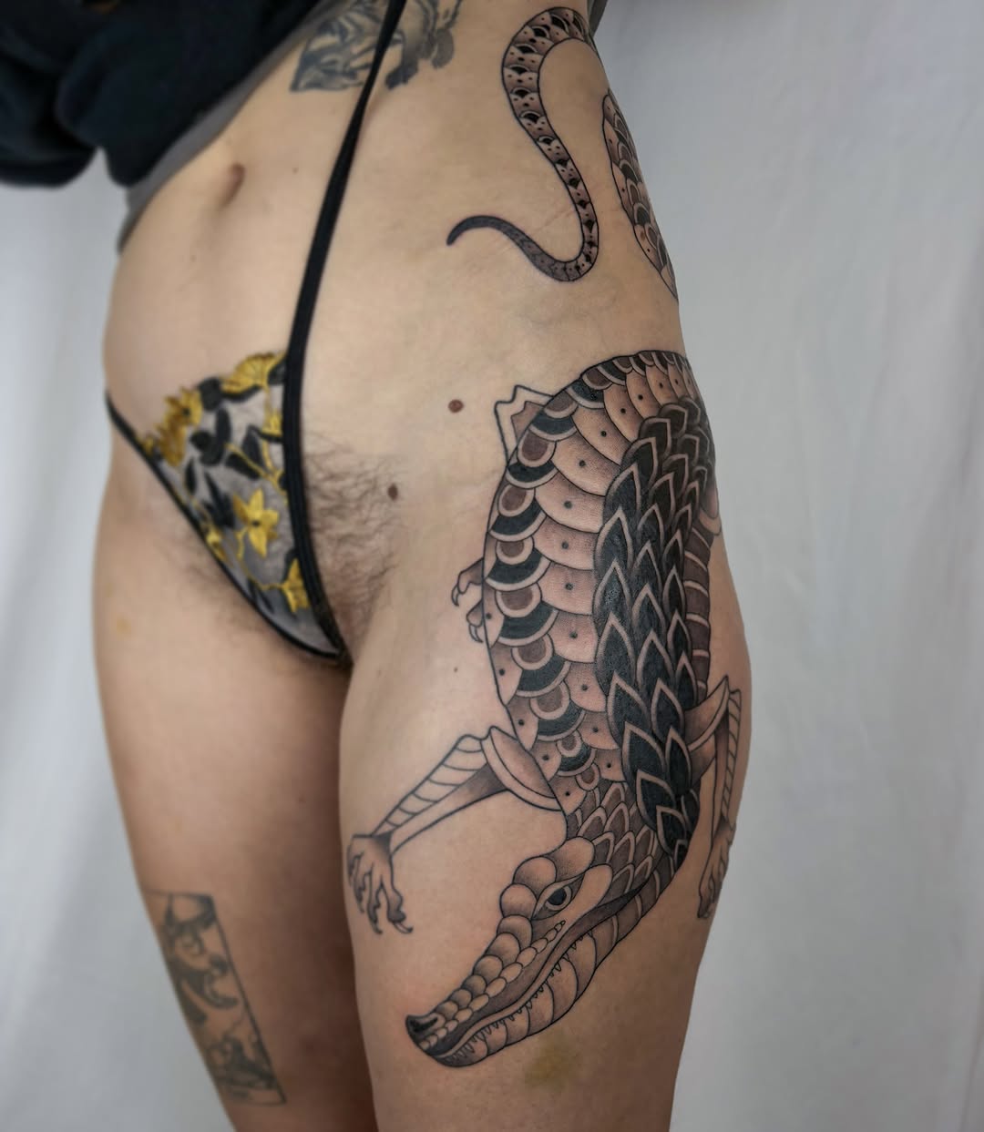 Dragon black and grey tattoo on the thigh by Anna Sage