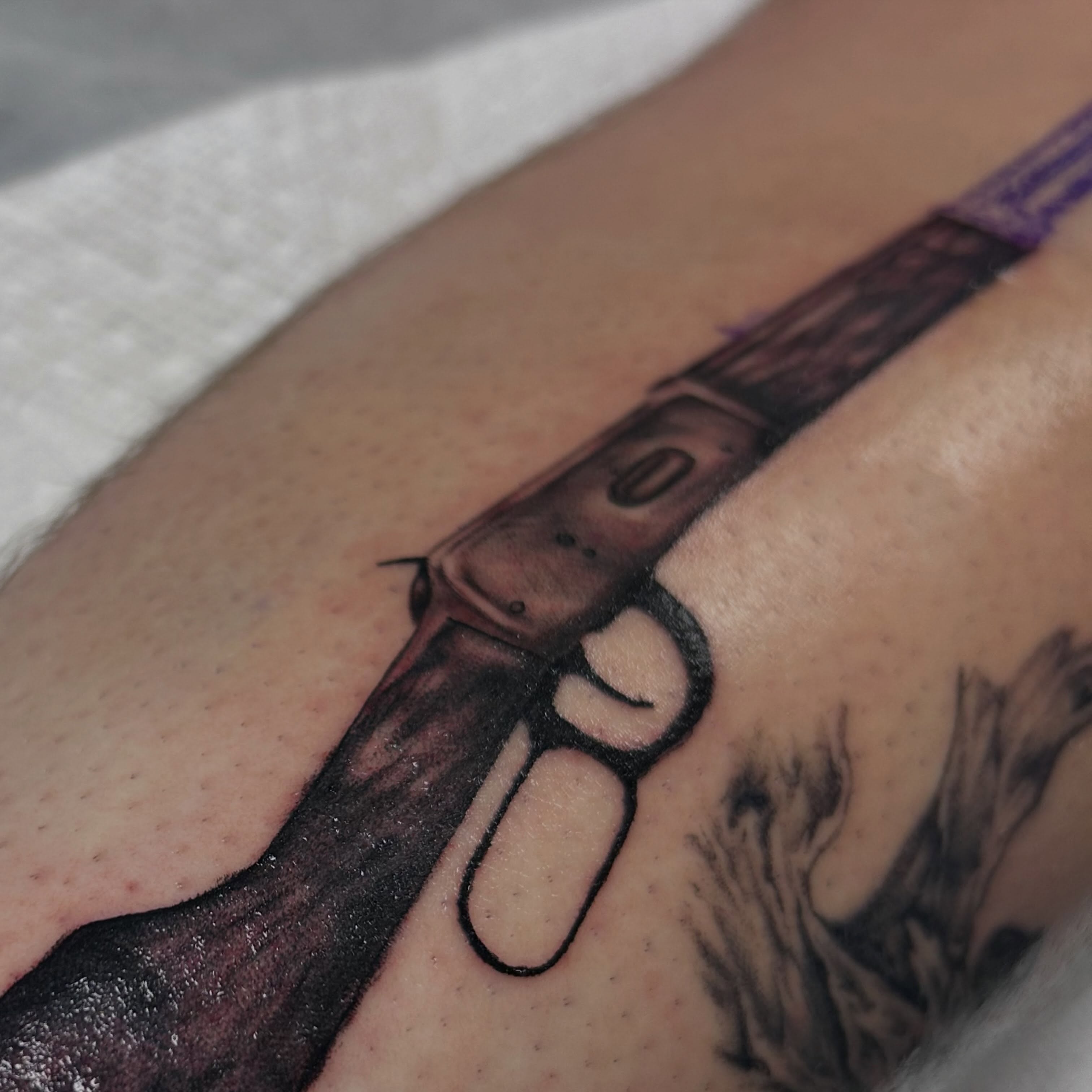 Gun black and grey tattoo on the forearm by Alex Lang