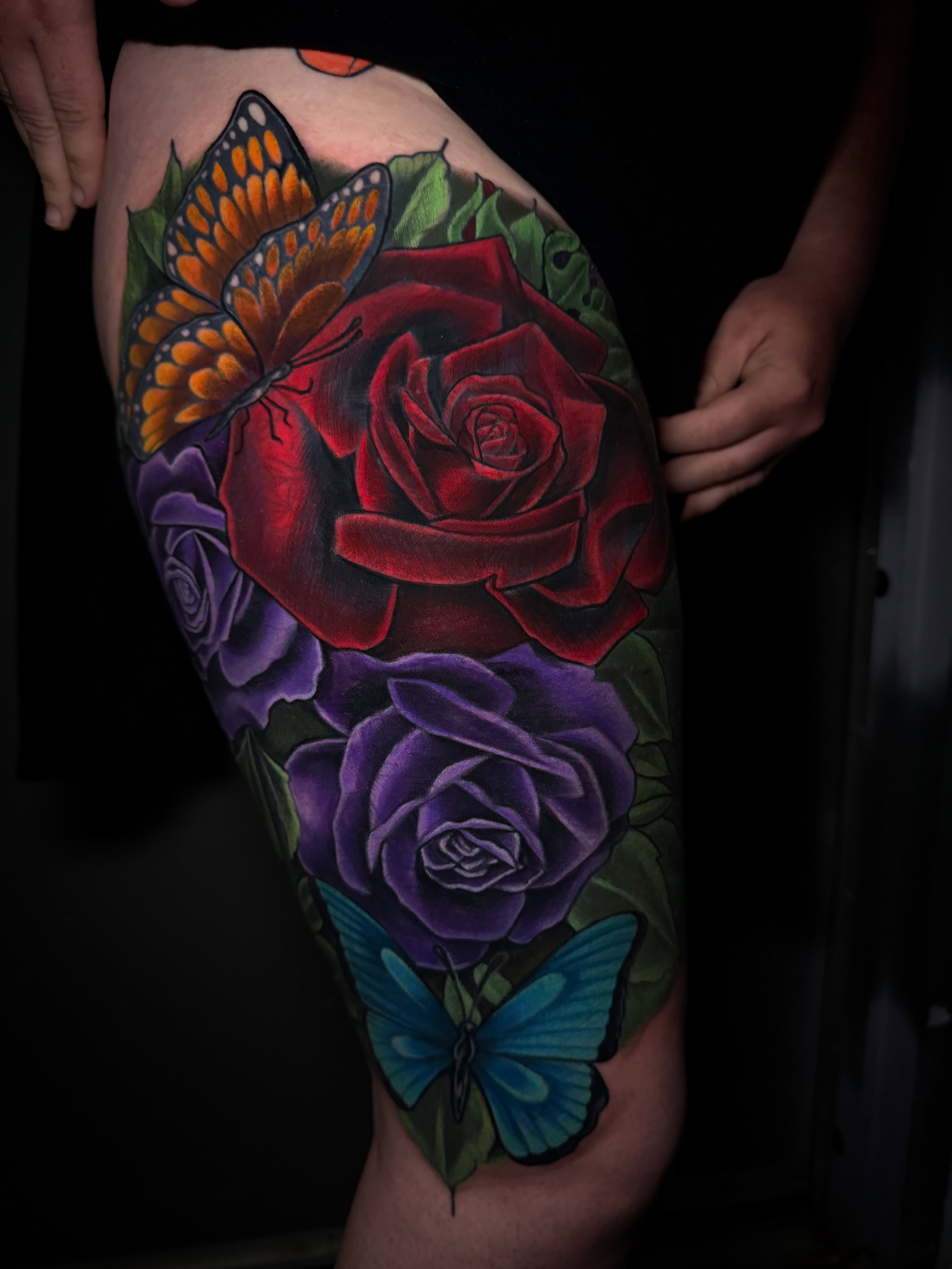 Red rose and butterflies realism tattoo on the thigh by Tyler Jewett