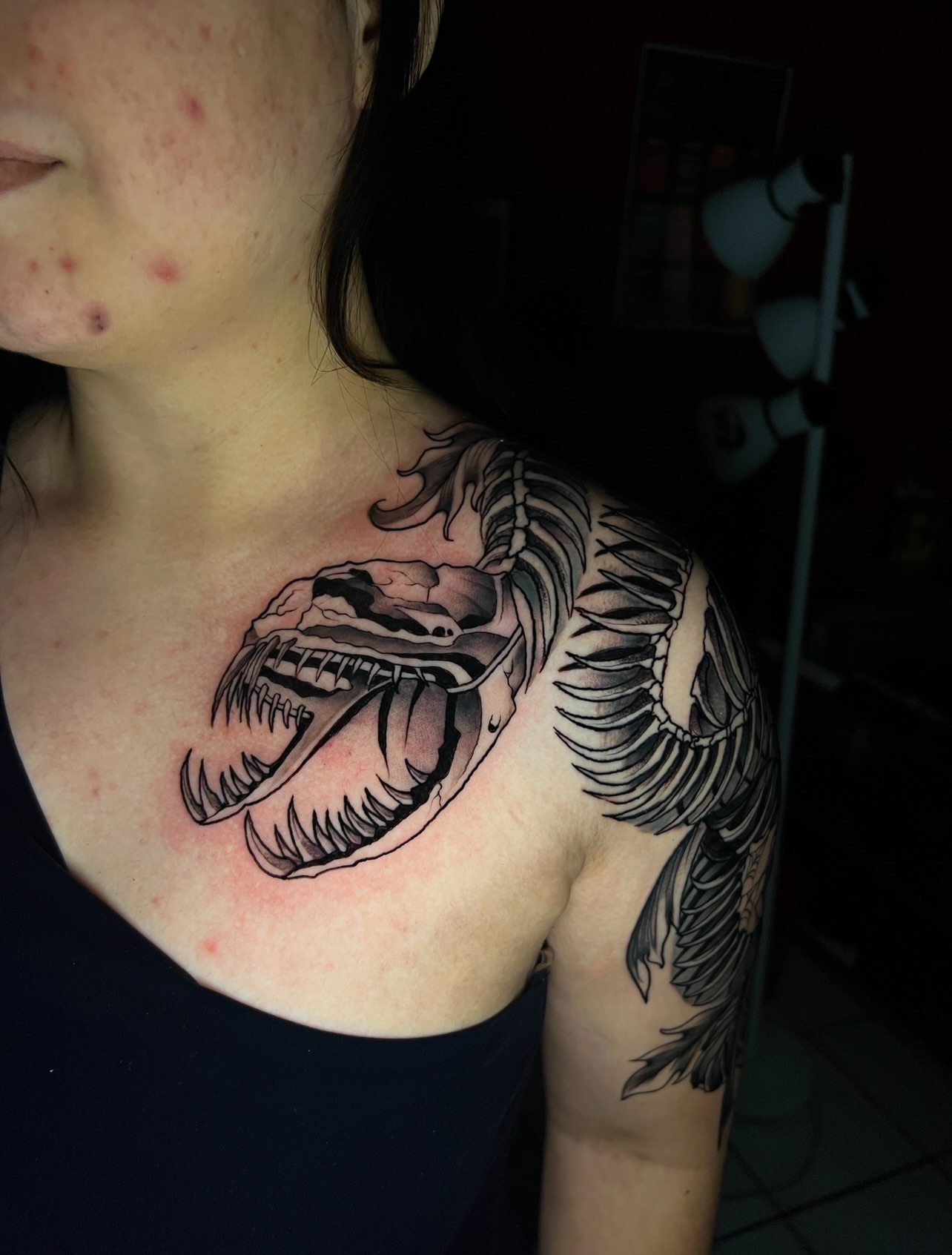 Dinosaur skeleton black and grey tattoo on the shoulder by El Salvador Tattoo Artist