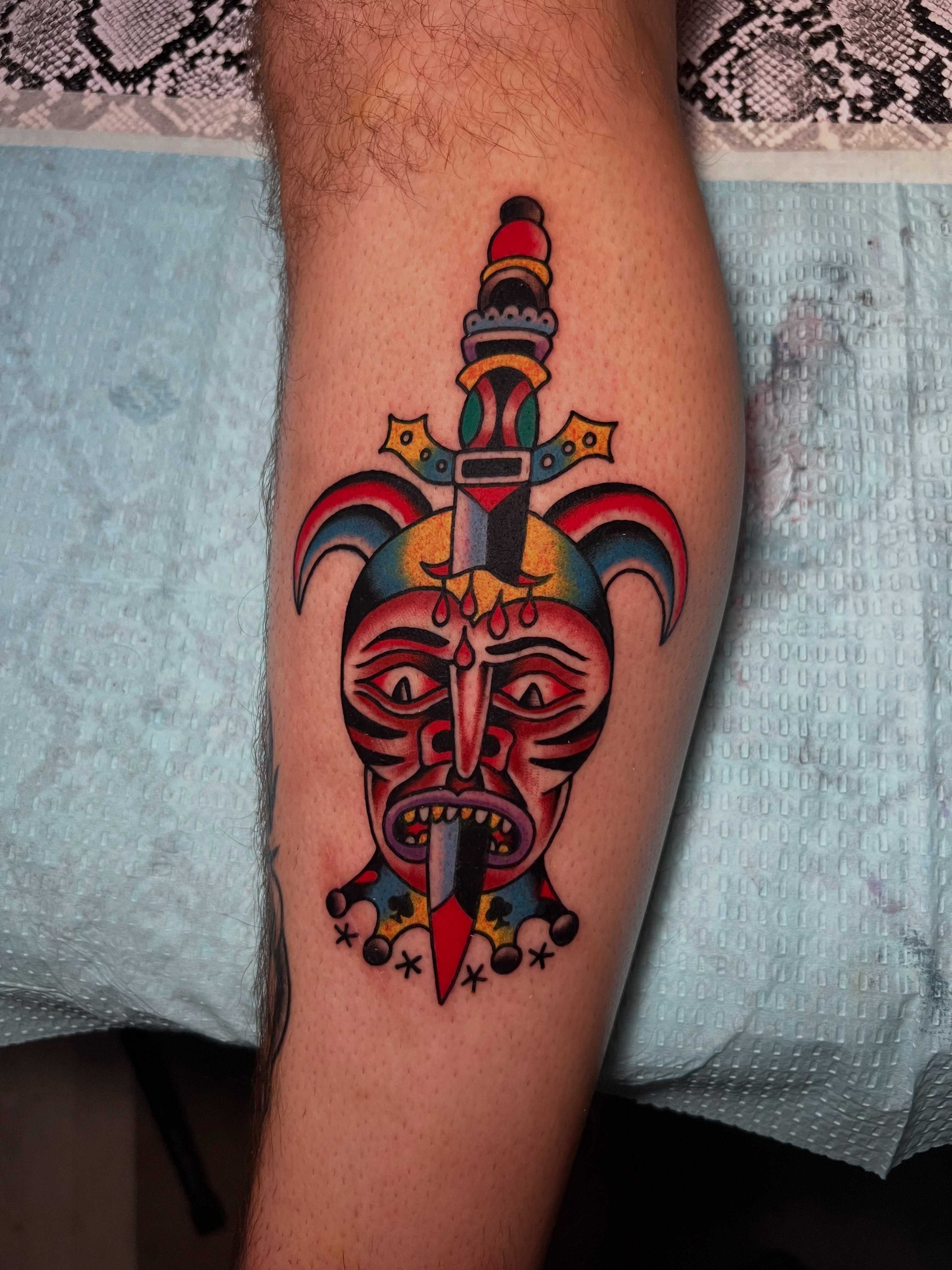 Jester mask American traditional tattoo on the forearm by Charlie Campanella