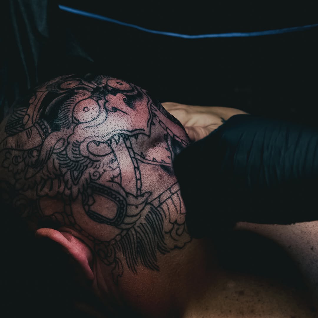 Mask dotwork tattoo on the chest by Leif Hansen