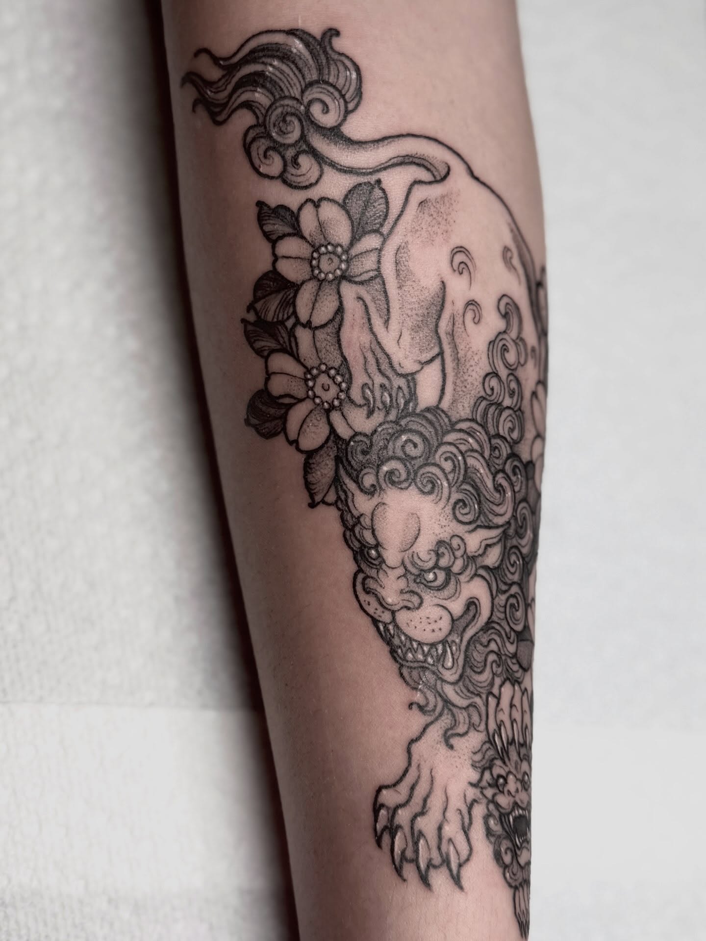 Koi fish and flowers dotwork tattoo on the forearm by Cincinnati