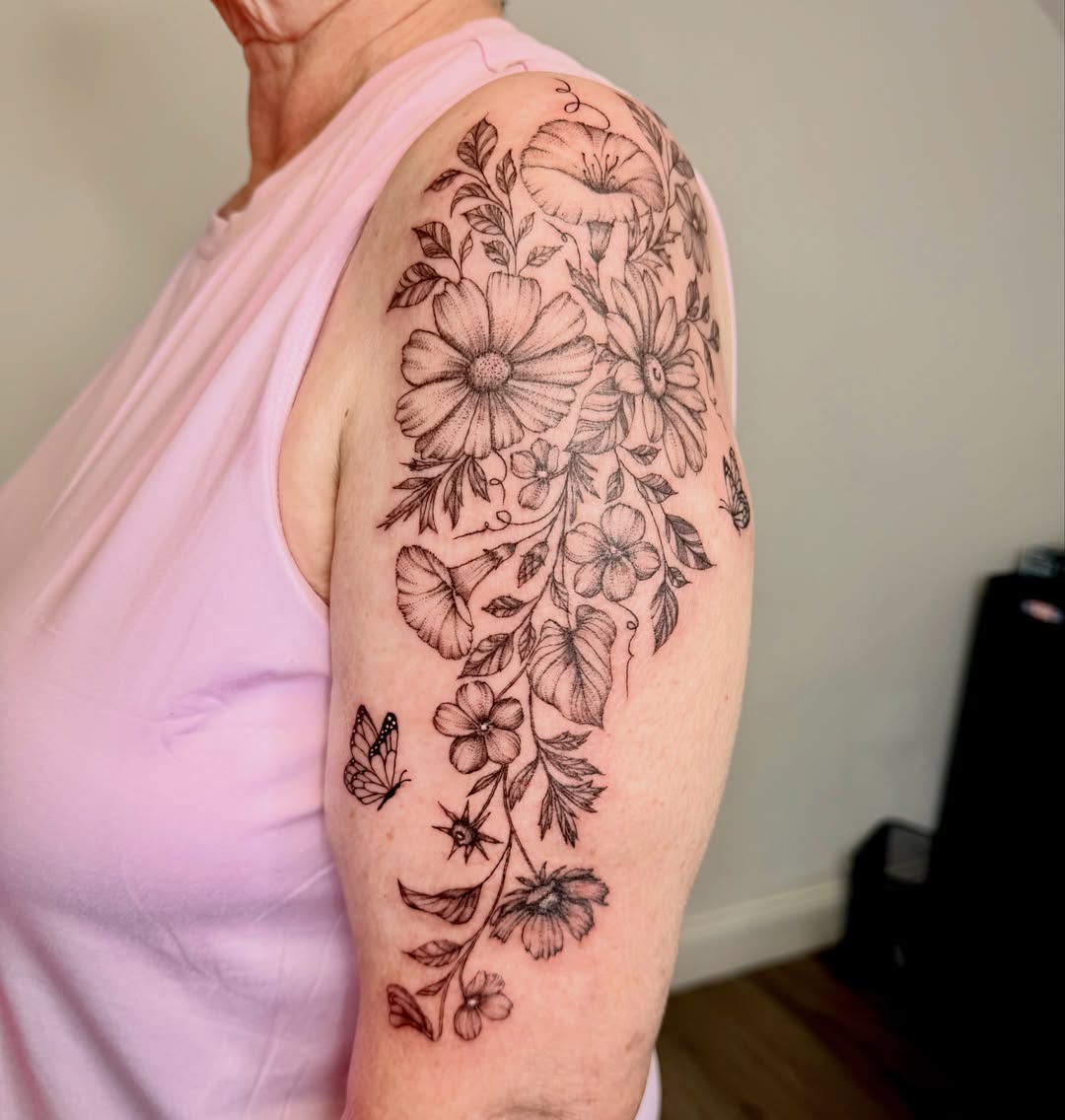 Floral vine fine line tattoo on the upper arm by Fine Line Tattoo Artist