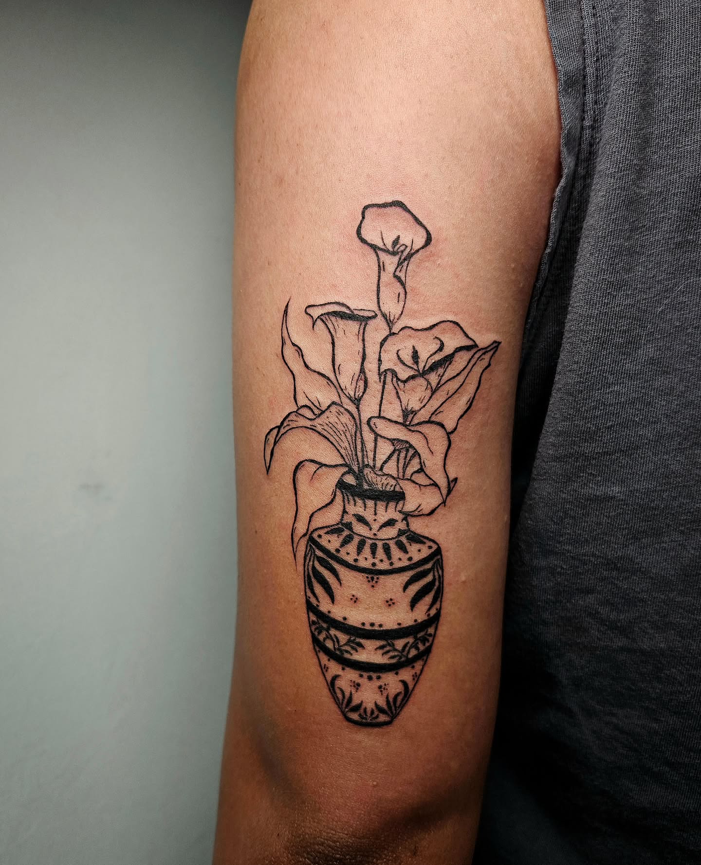 Calla lilies in vase black and grey tattoo on the forearm by Lina ๐ป