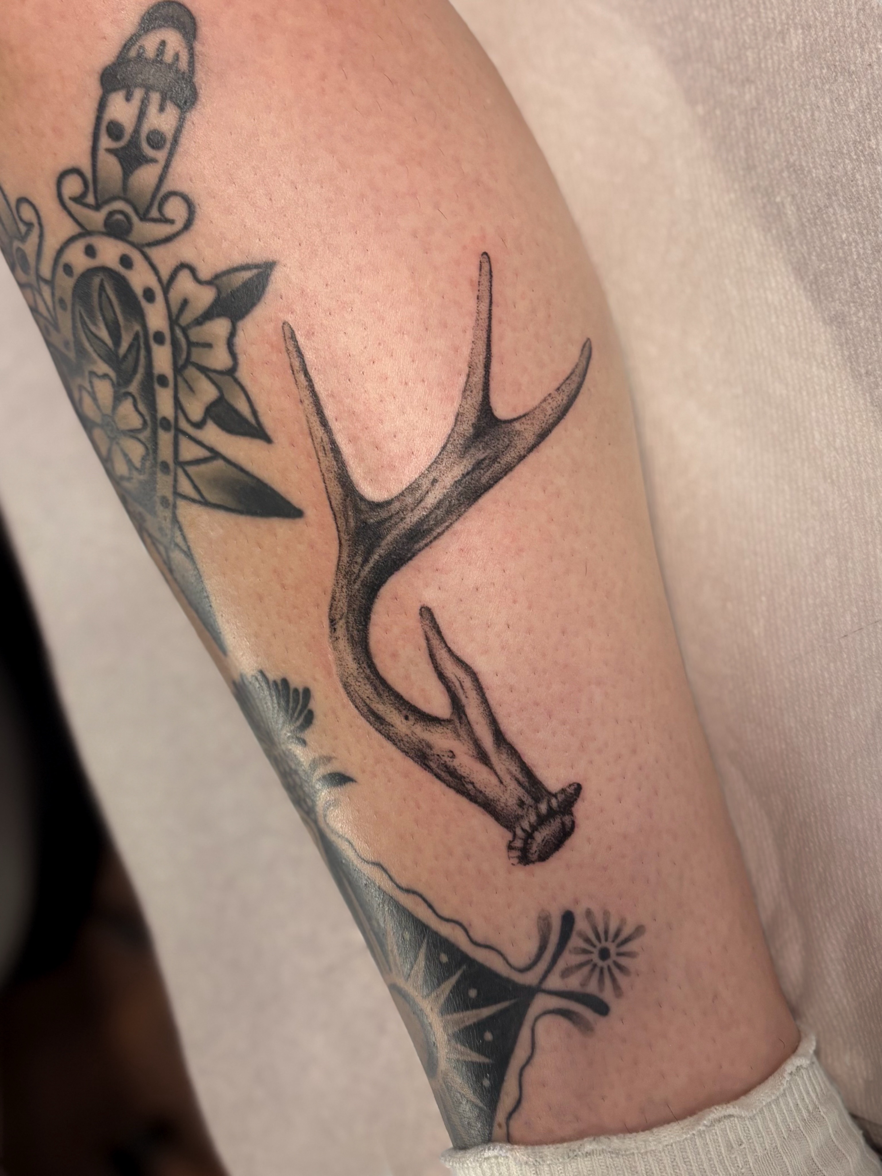 Antlers and flowers black and grey tattoo on the forearm by laika ✶ pdx tattoo, Portland, Oregon