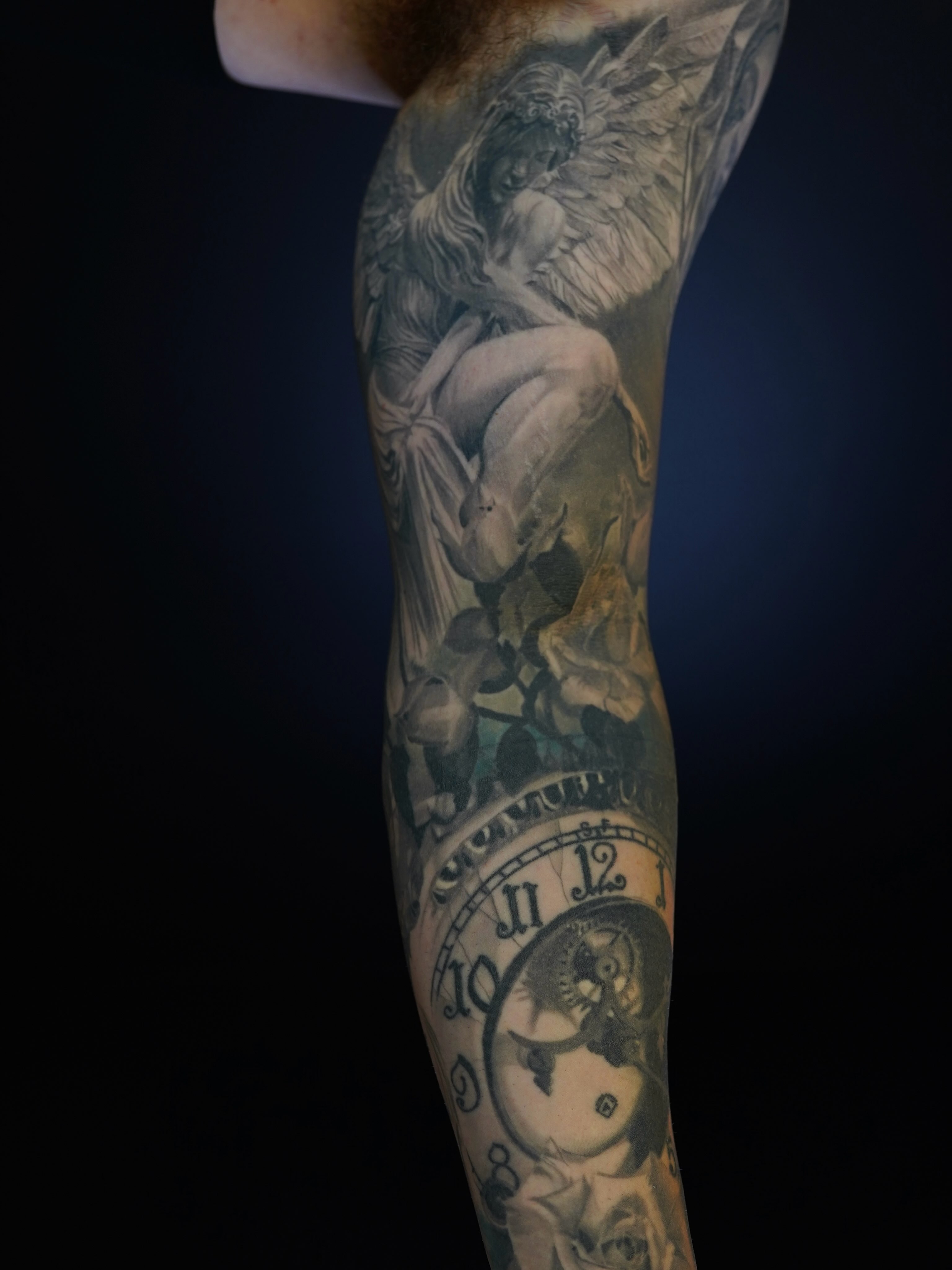 Angel and clock realism tattoo on the forearm by Eric RudeInk