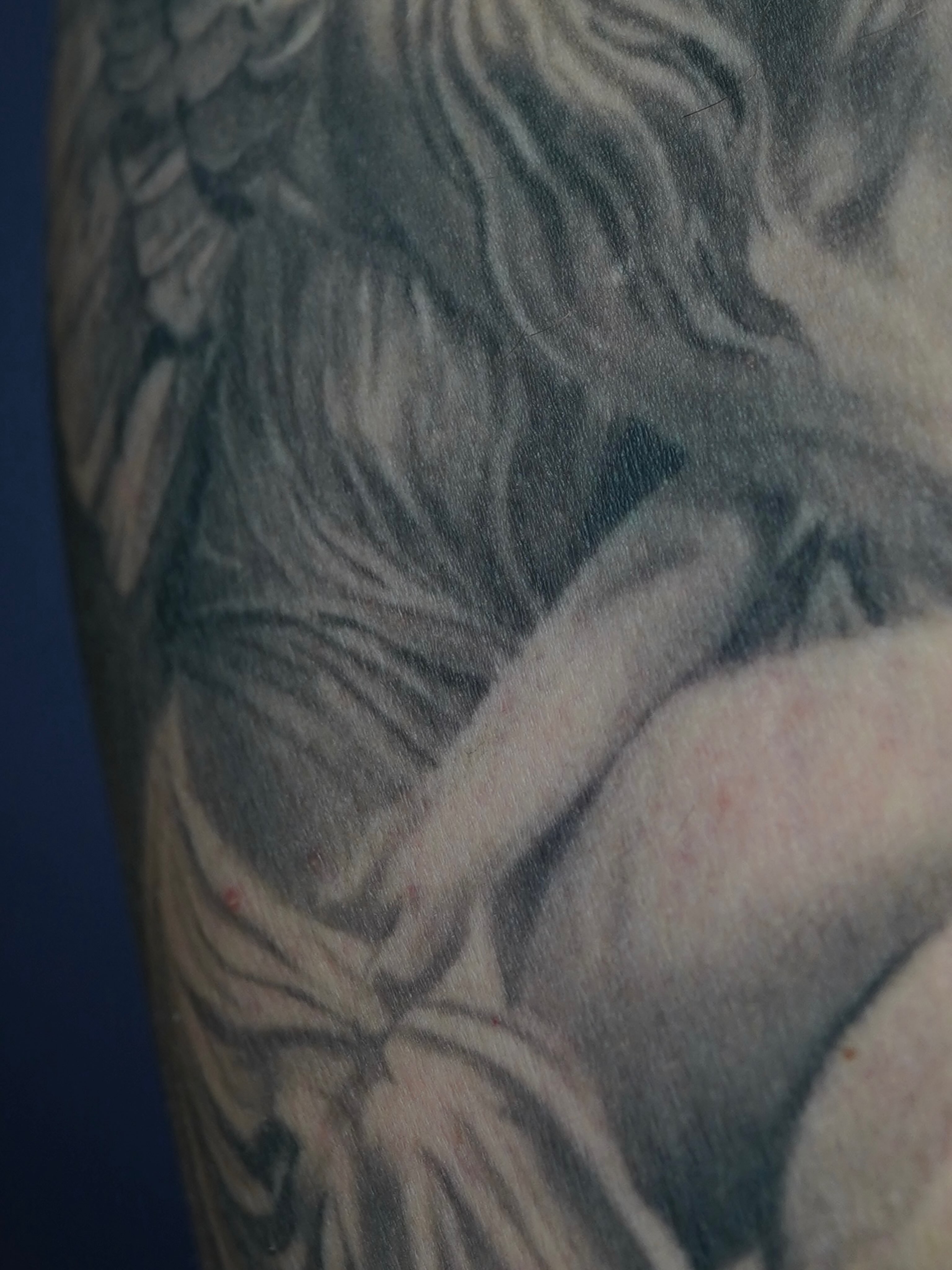 Naked woman black and grey tattoo on the upper arm by Eric RudeInk