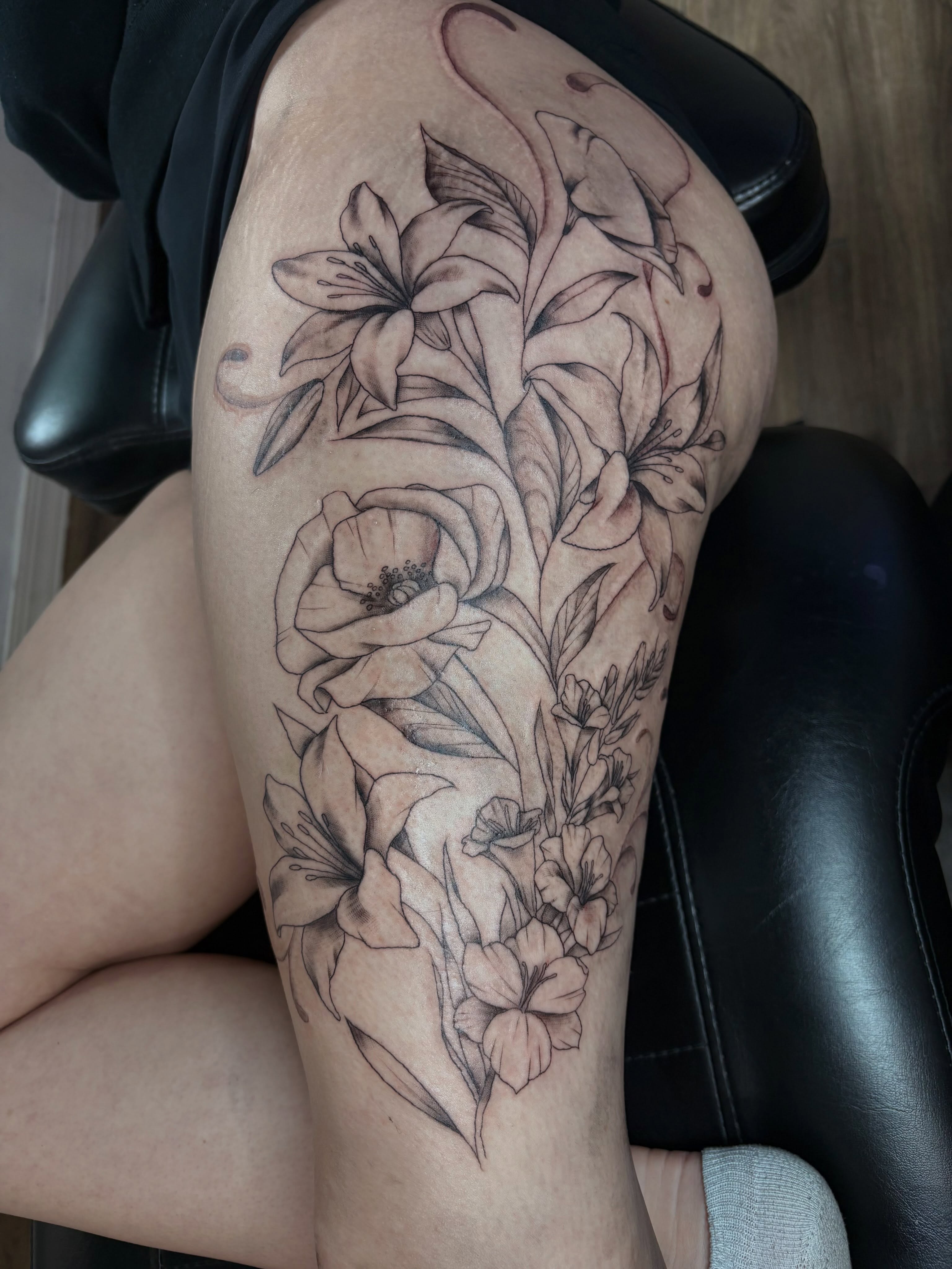 Floral arrangement realism tattoo on the thigh by Cincinnati Tattoo Artist