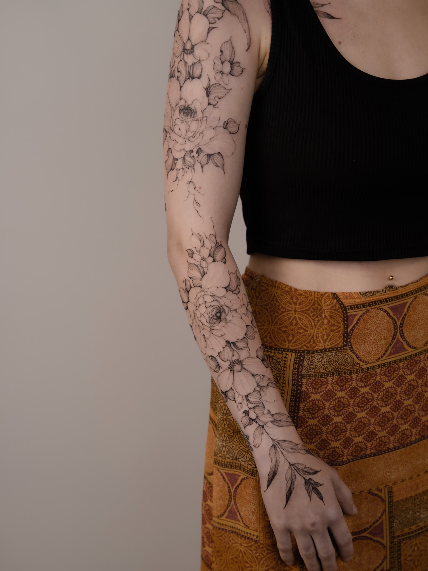 Floral bouquet black and grey tattoo on the upper arm by Marek