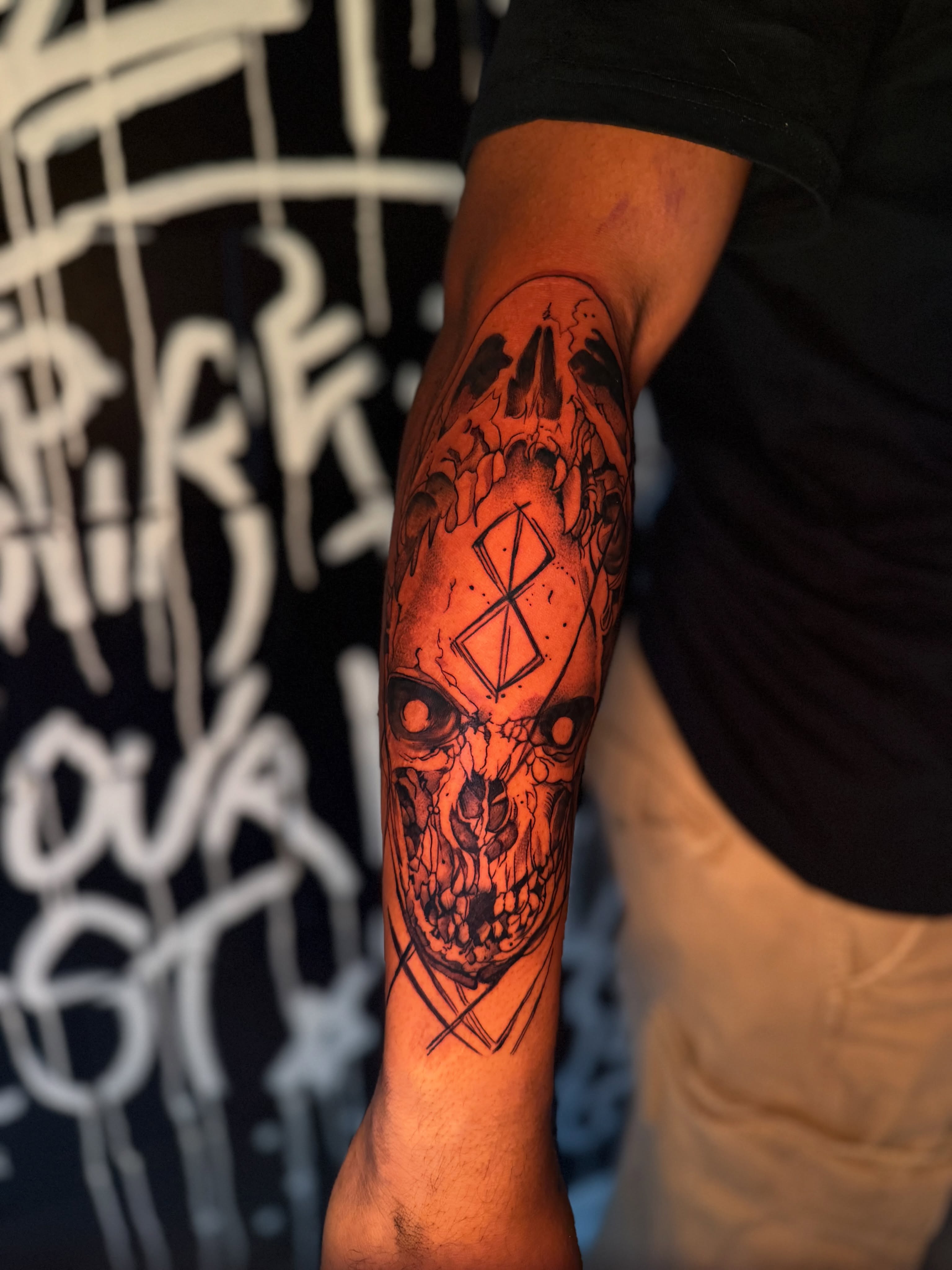 Skull with geometric symbol dark realism tattoo on the forearm by Savannah Tattoo Artist