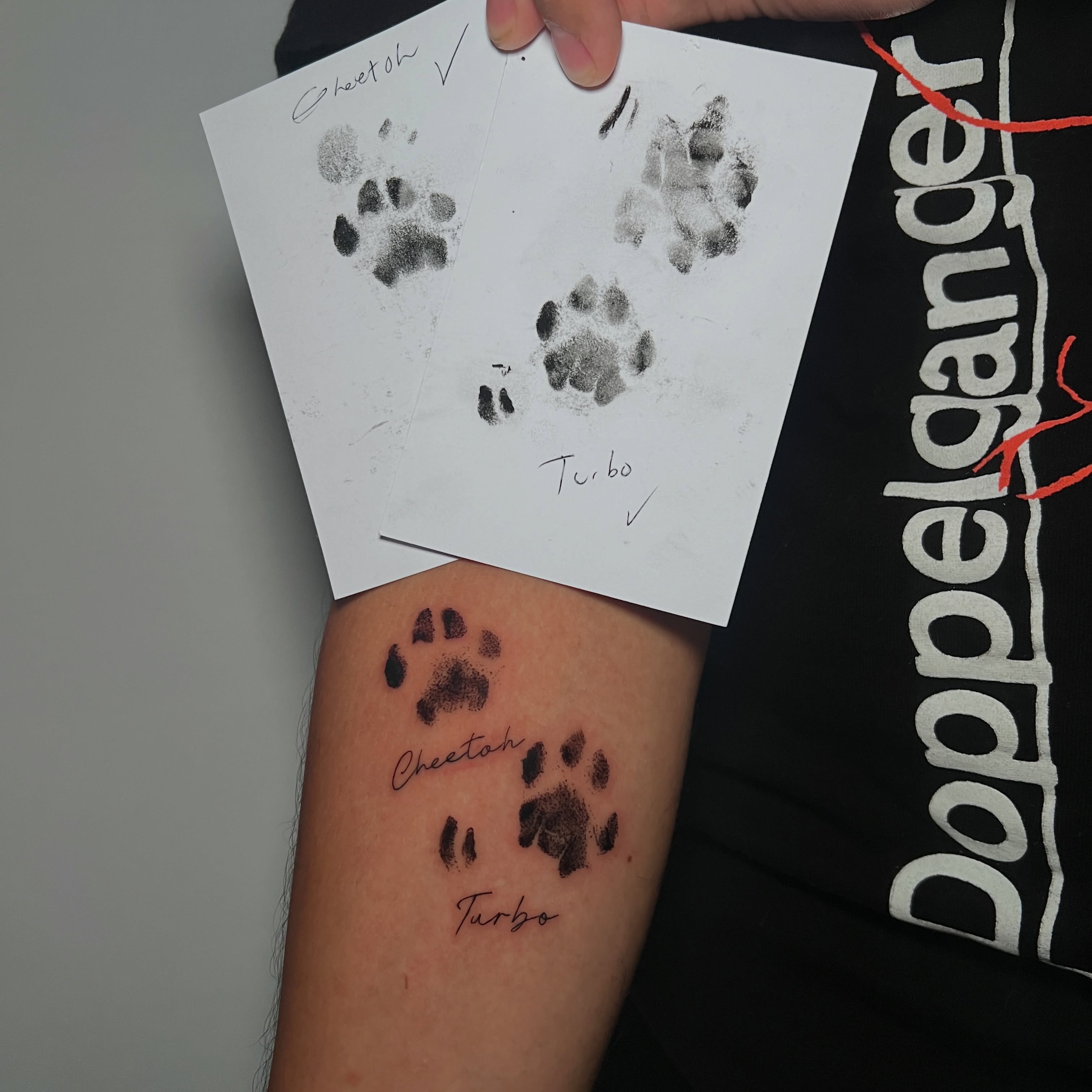 Paw prints black and grey tattoo on the forearm by Eleana, North Miami, Florida