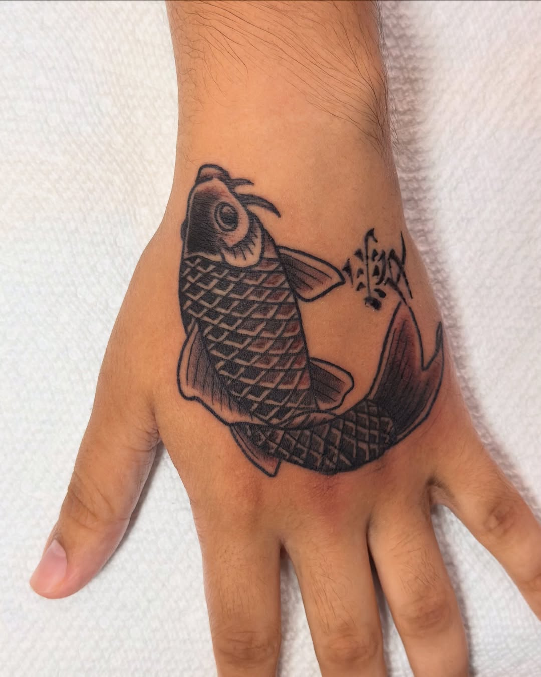 Koi fish black and grey tattoo on the hand by Andre Guerra