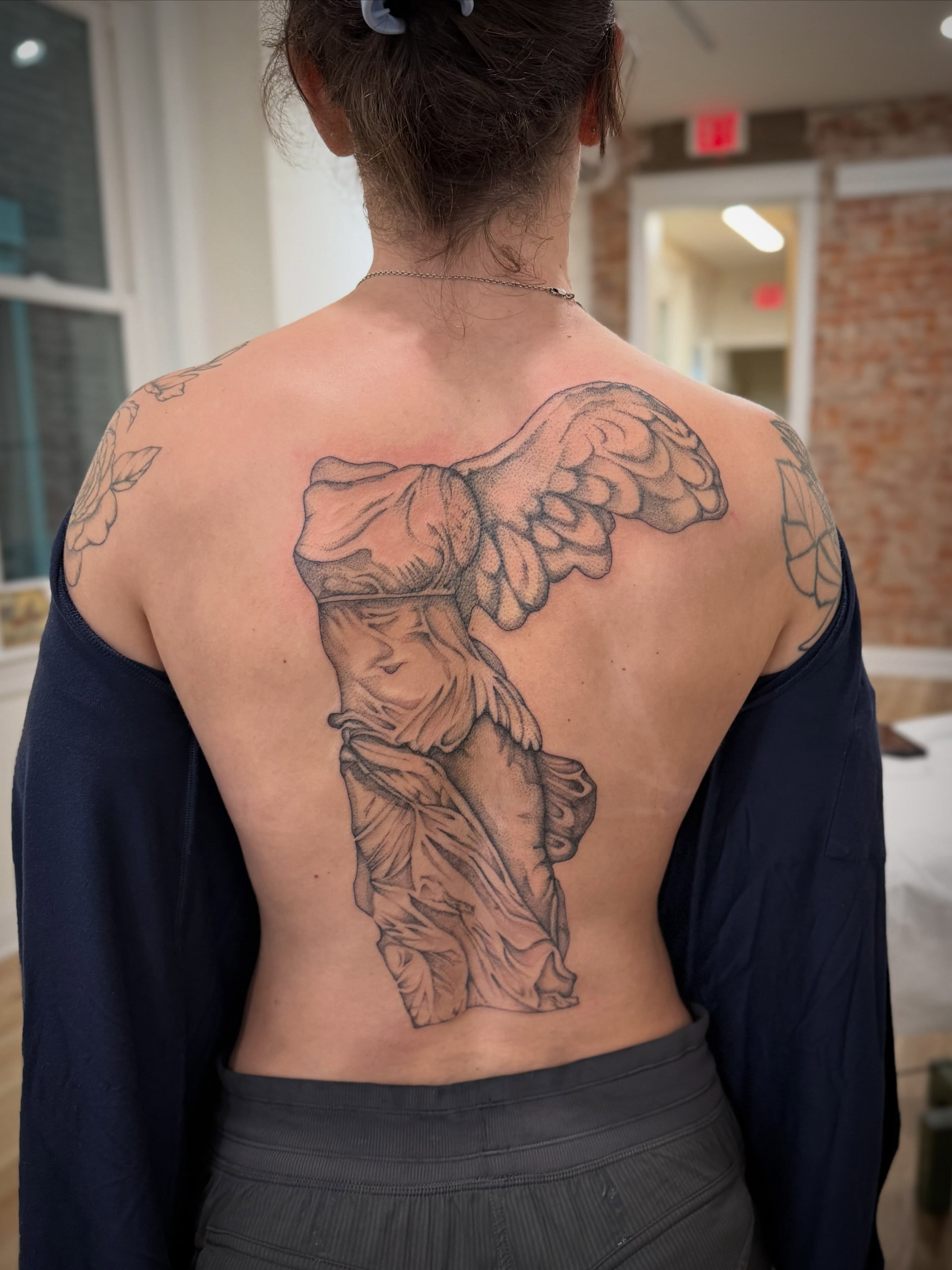 Statue of winged woman realism tattoo on the back by Daniel Anthony, Philadelphia, Pennsylvania
