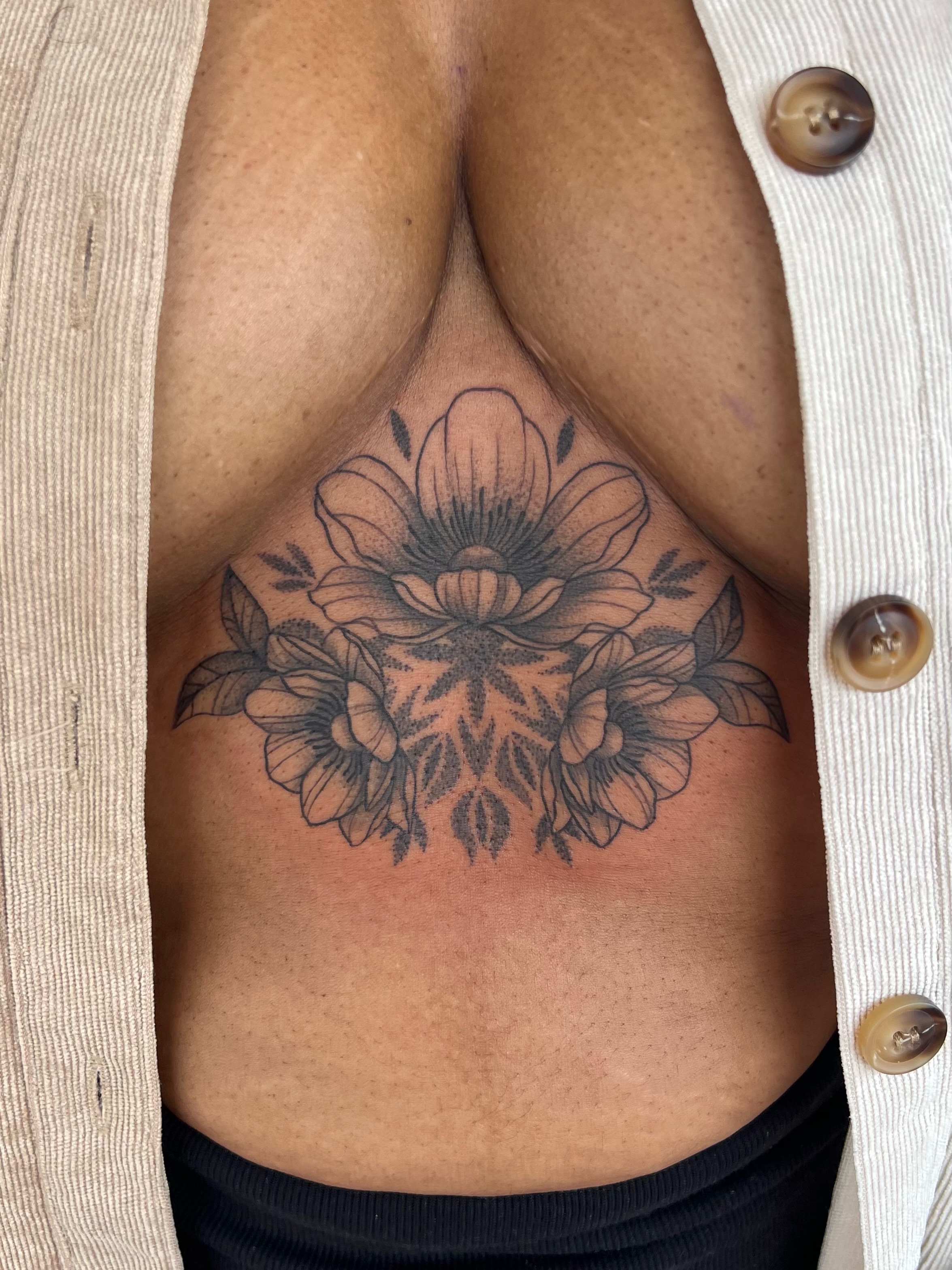 Floral arrangement black and grey tattoo on the chest by Jai Woods