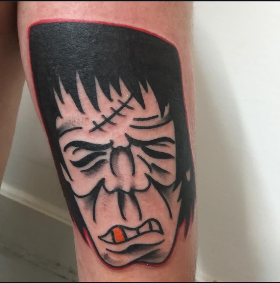 Angry face American traditional tattoo on the forearm by dave rash