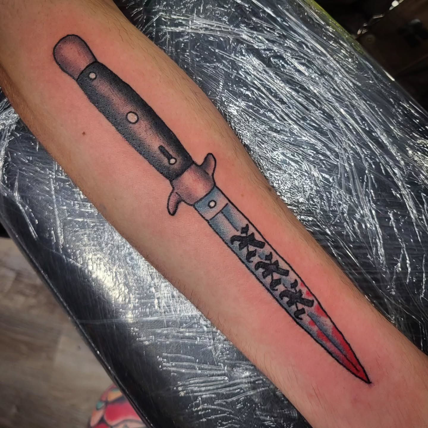 Knife black and grey tattoo on the forearm by Sloan Smith