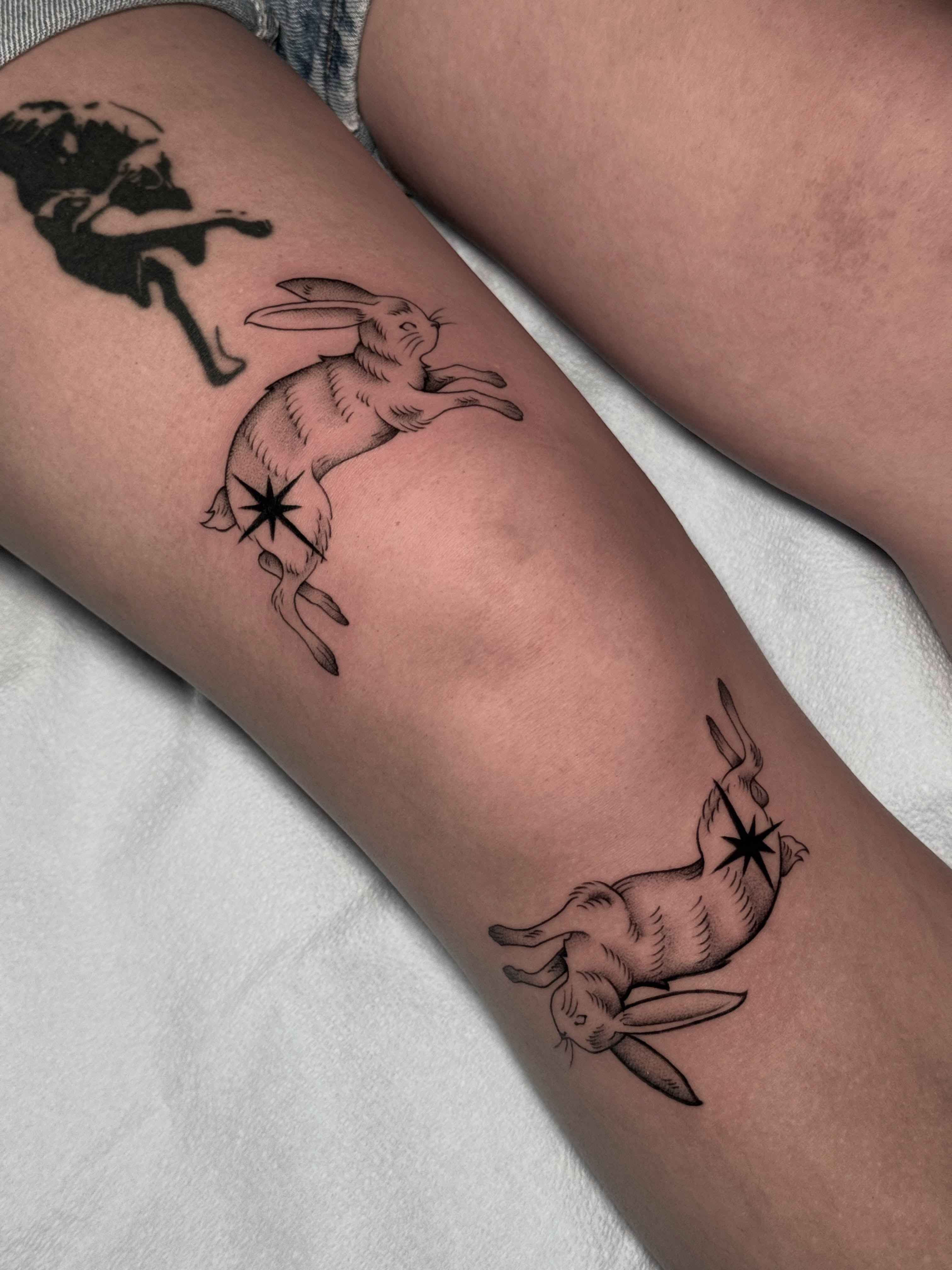 Hopping rabbit black and grey tattoo on the forearm by Carlos Abad