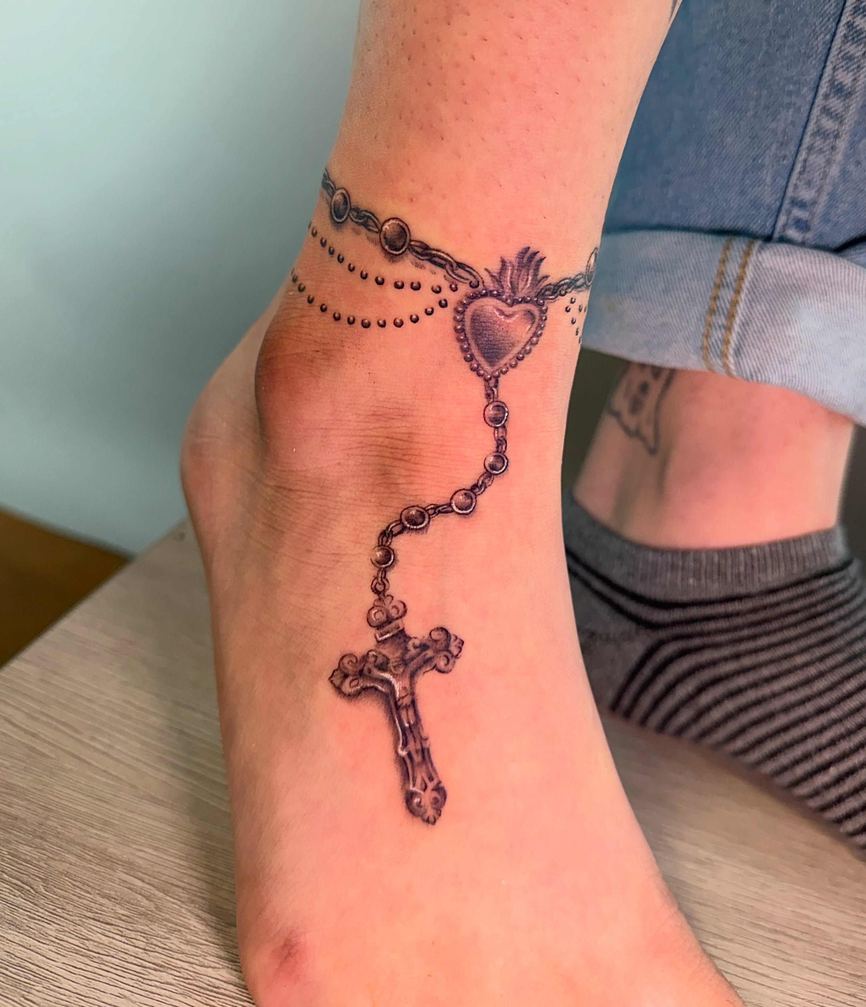Rosary black and grey tattoo on the foot by Erika Nambo