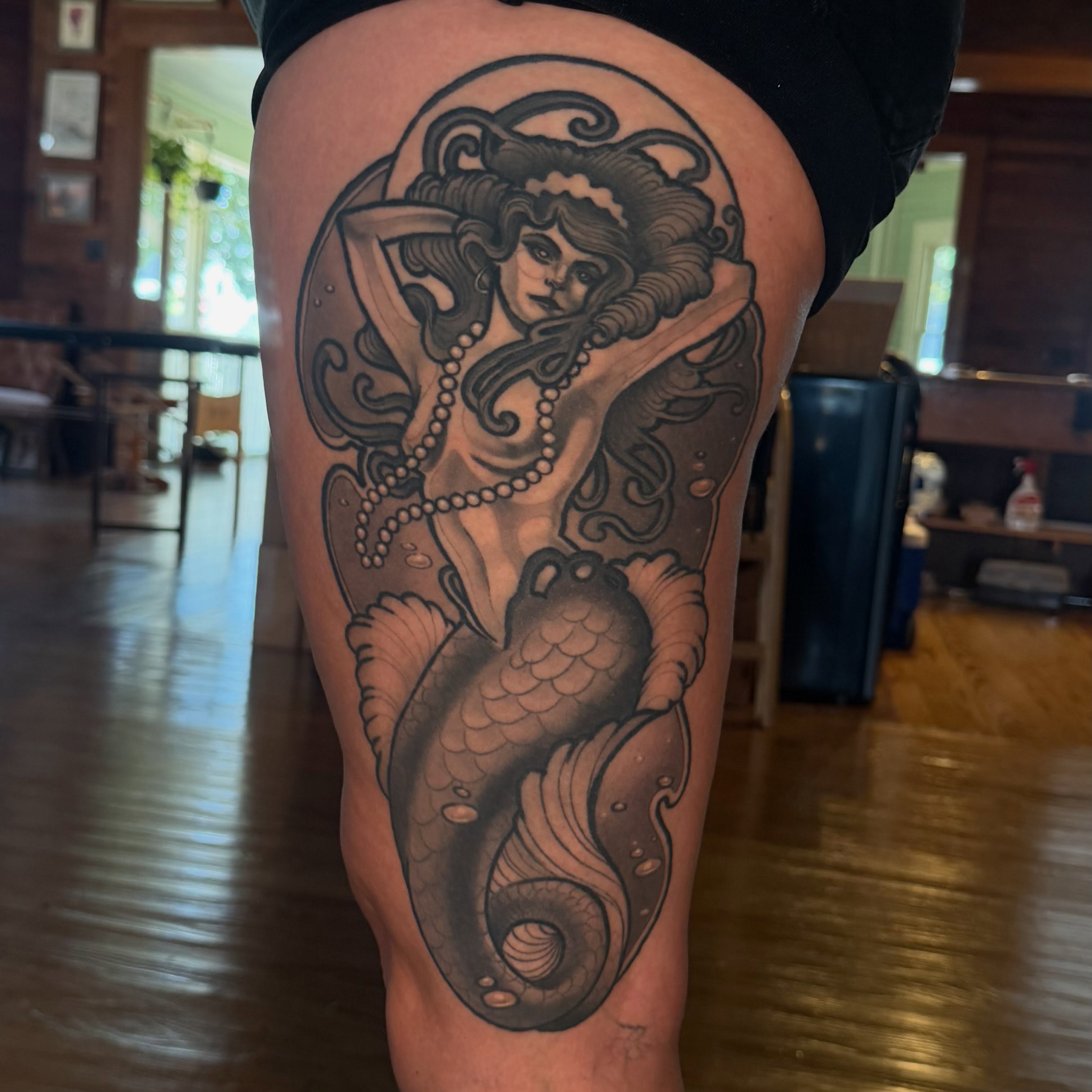 Mermaid black and grey tattoo on the thigh by Nathan Thomas
