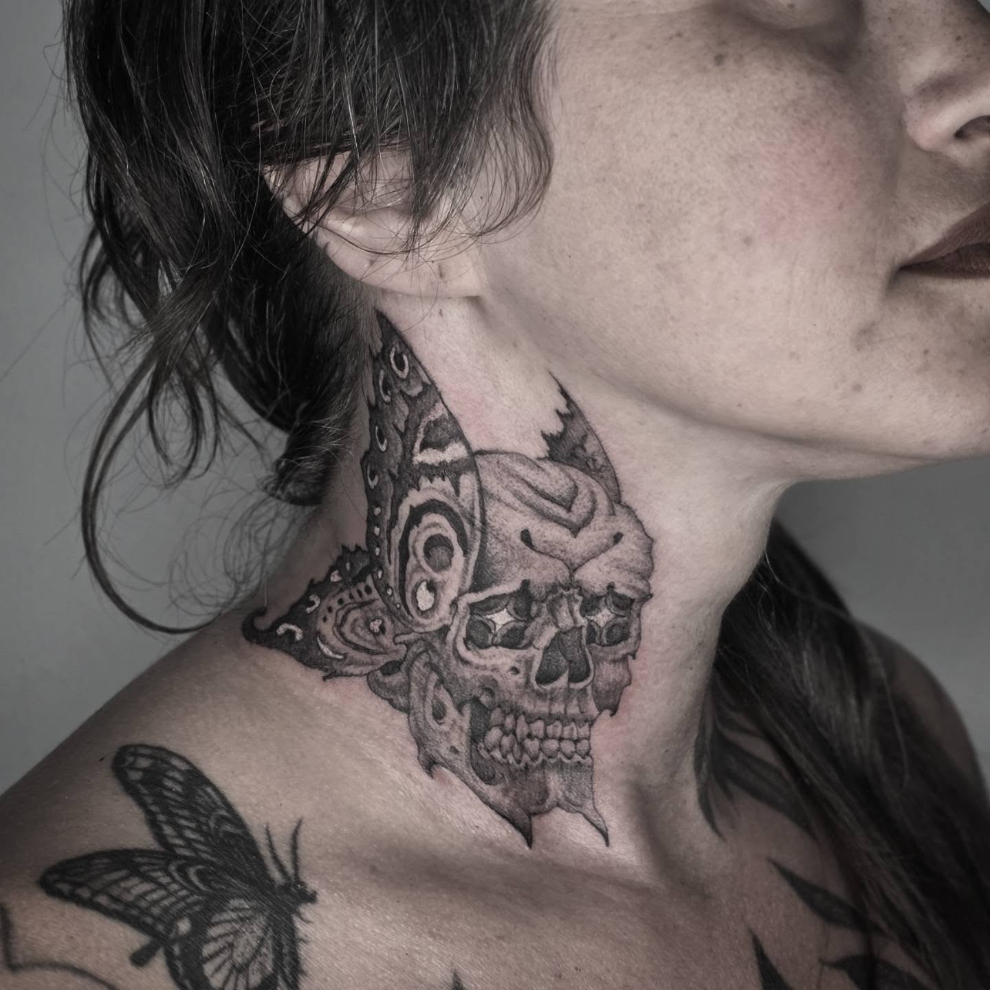 Skull and butterfly realism tattoo on the neck by Aaron Dor